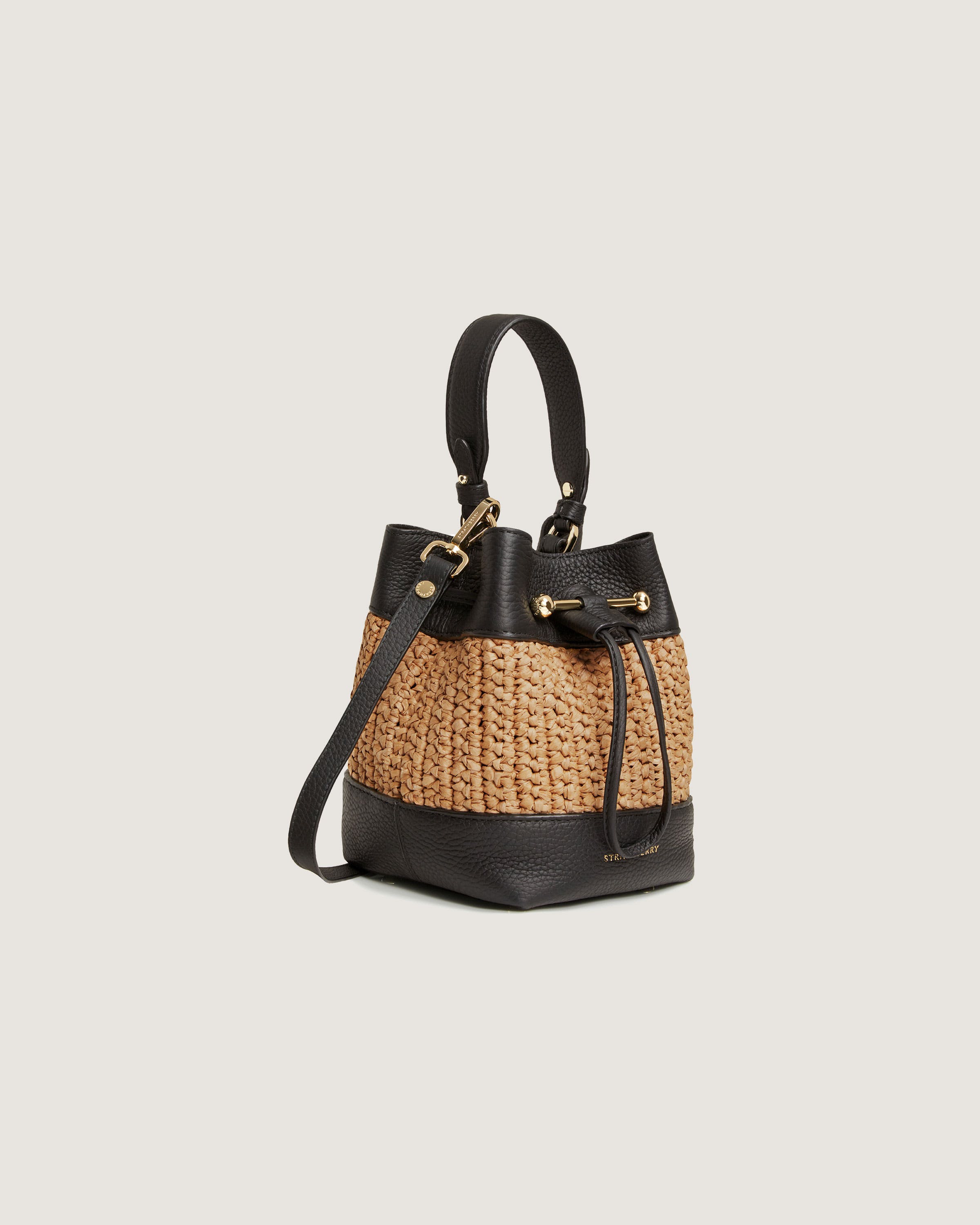 A straw bag with a black leather handle