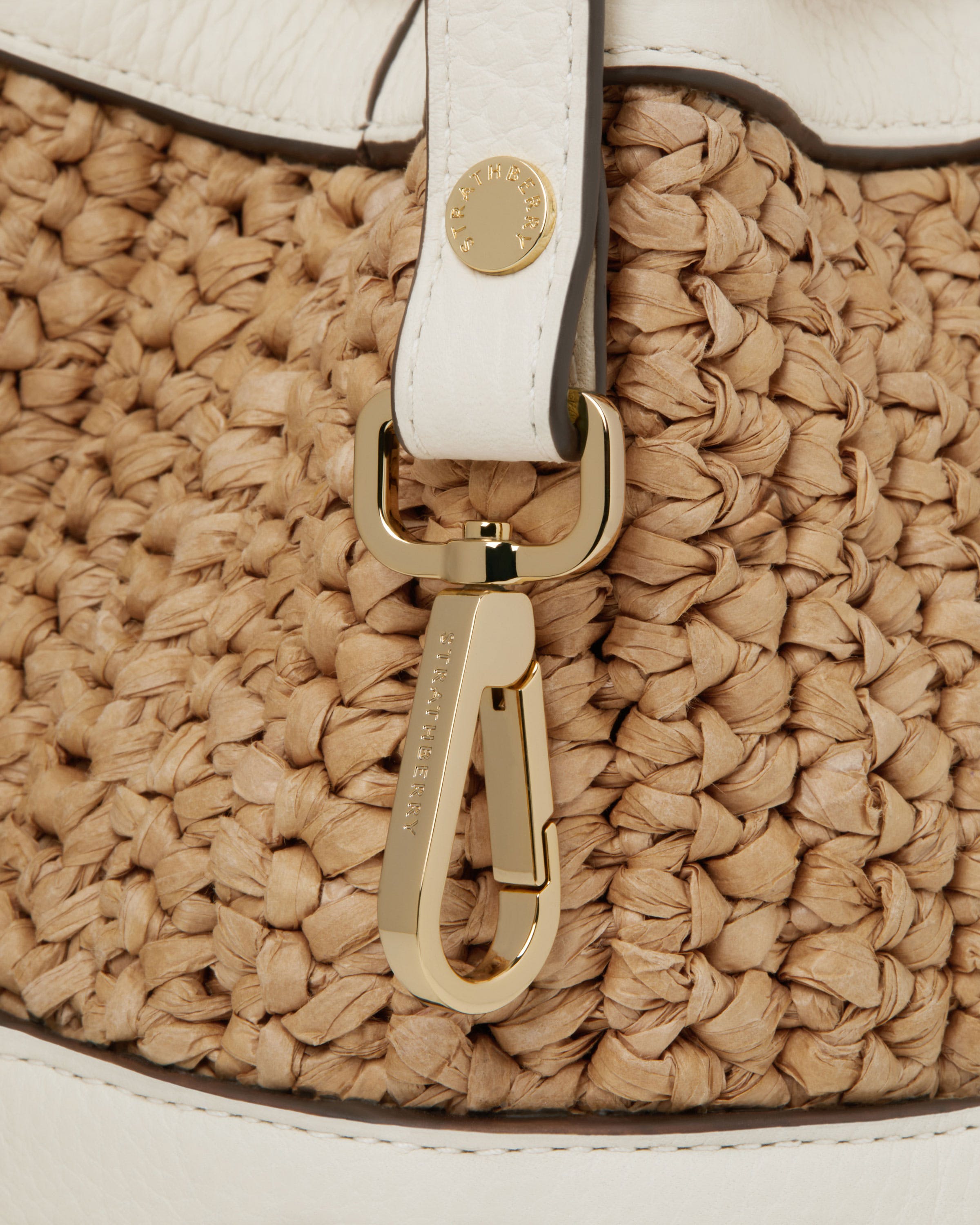 A close up of a handbag with a white strap