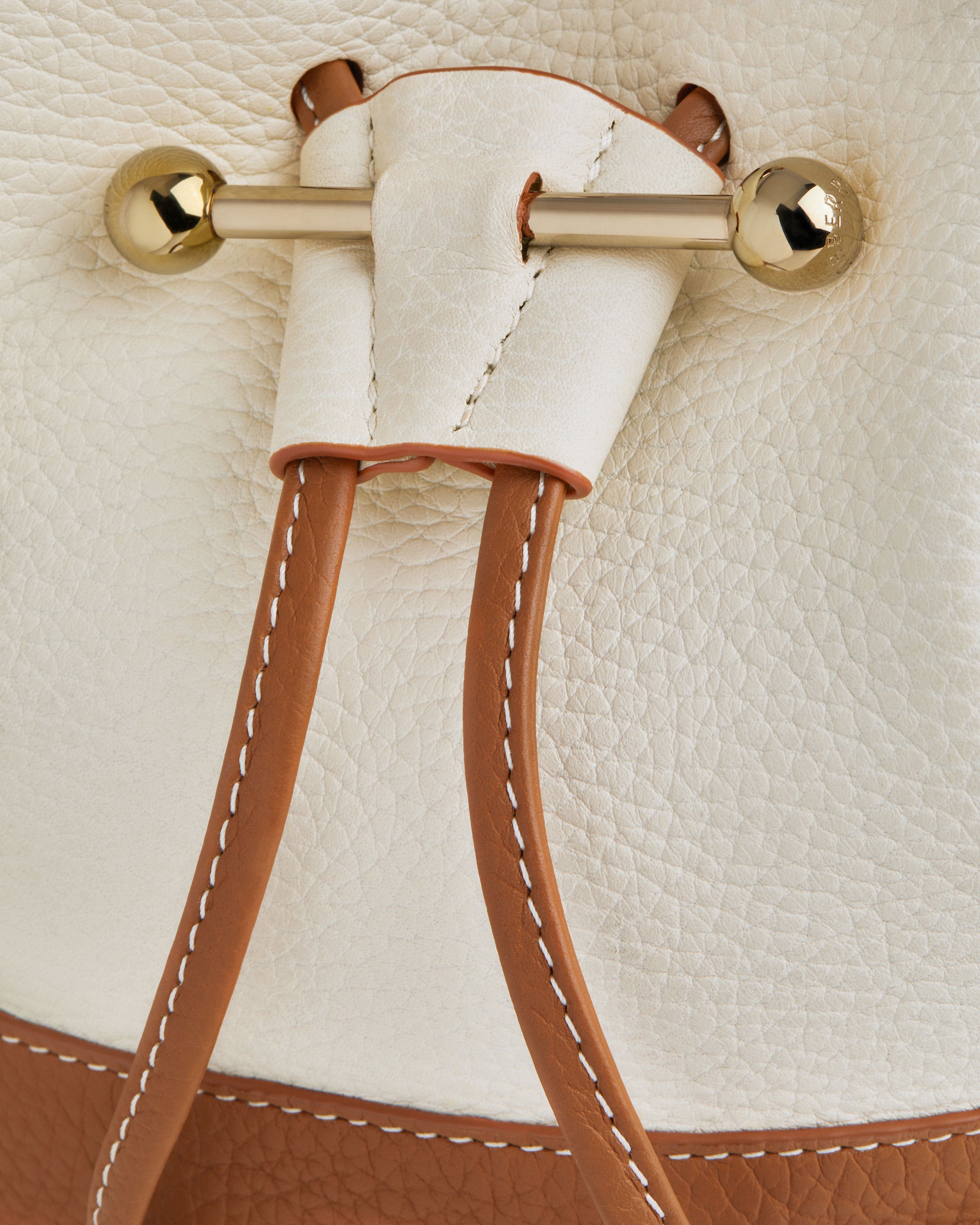 A close up of a white and brown purse