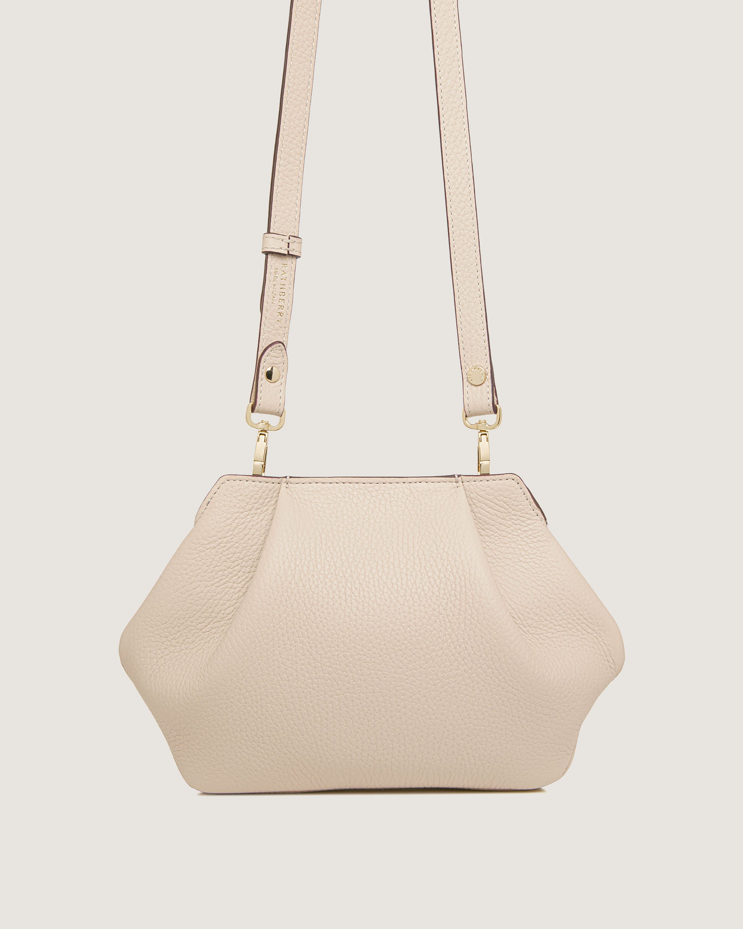 A white purse with a strap hanging from it