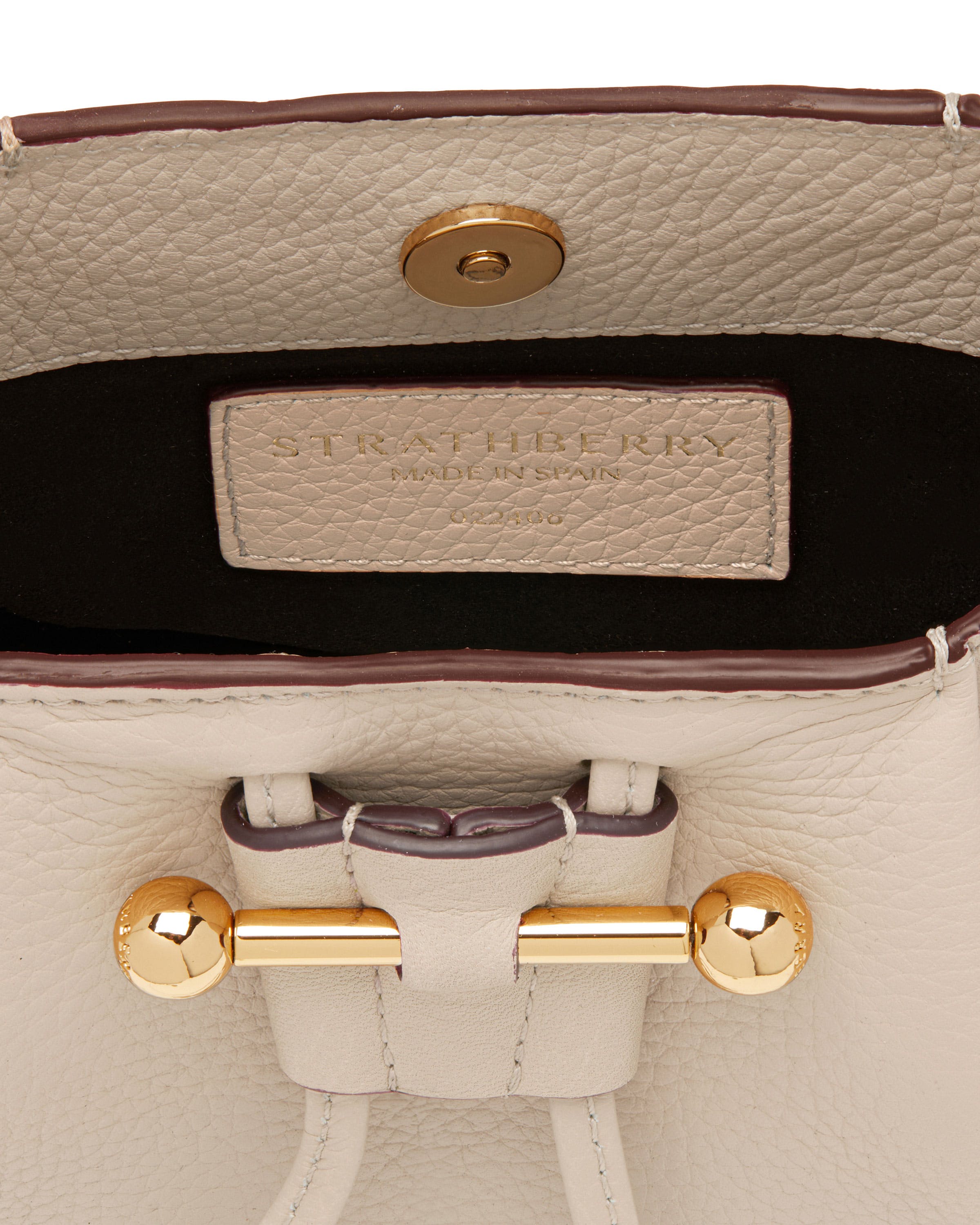 A close up of a white purse with a gold handle