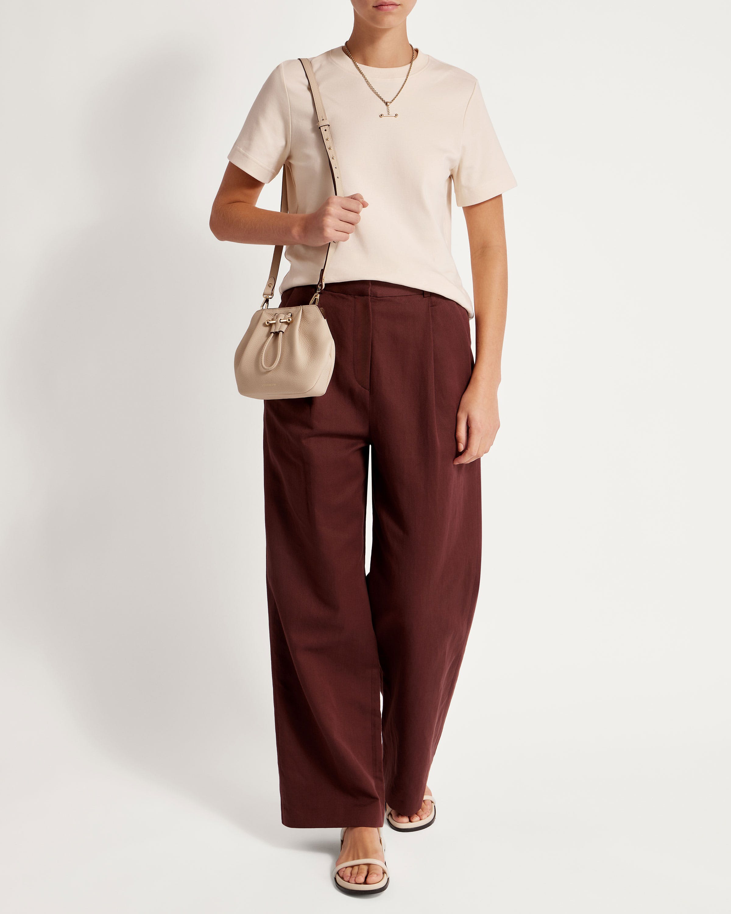 A woman in a white shirt and brown pants