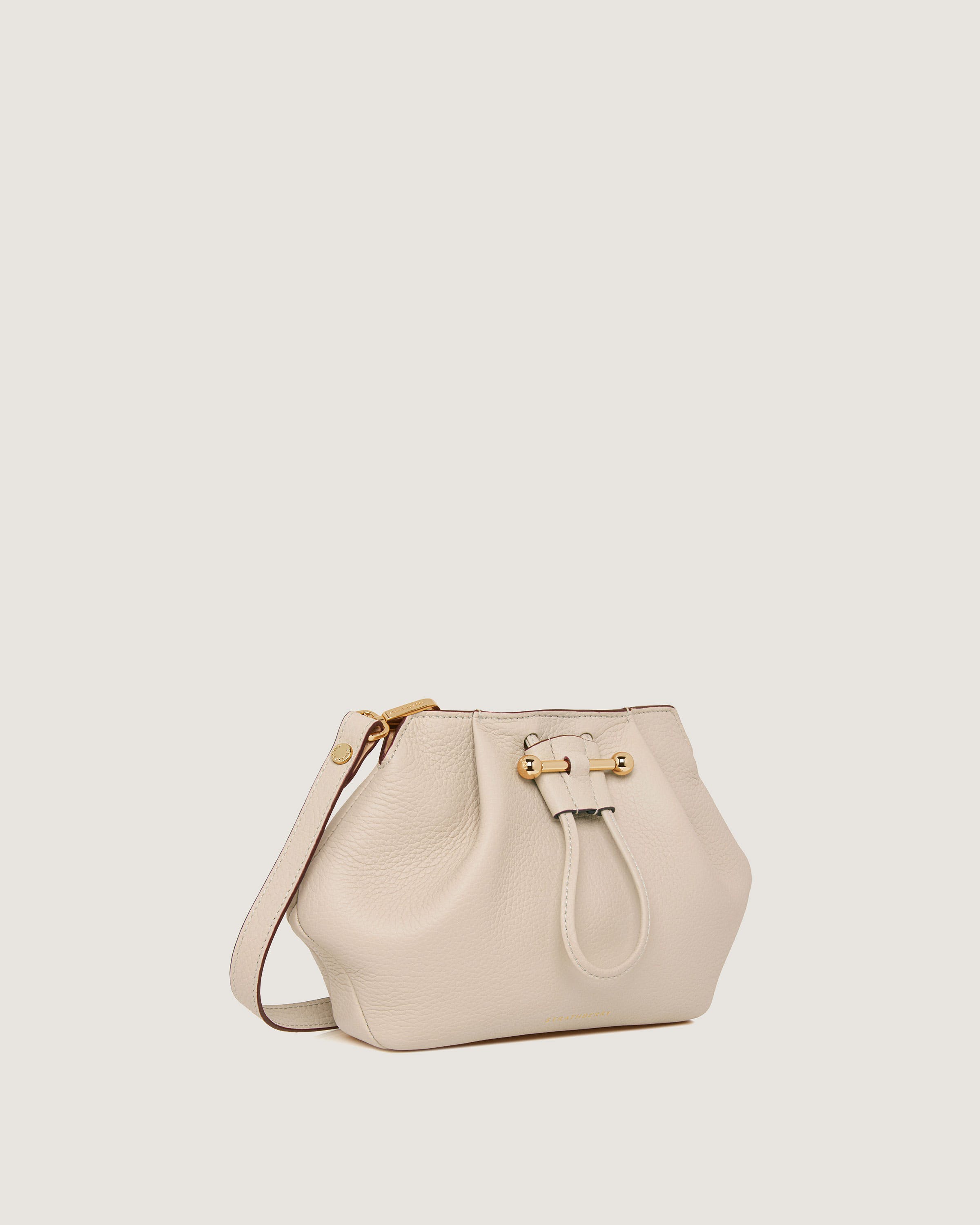 A white handbag with a gold buckle