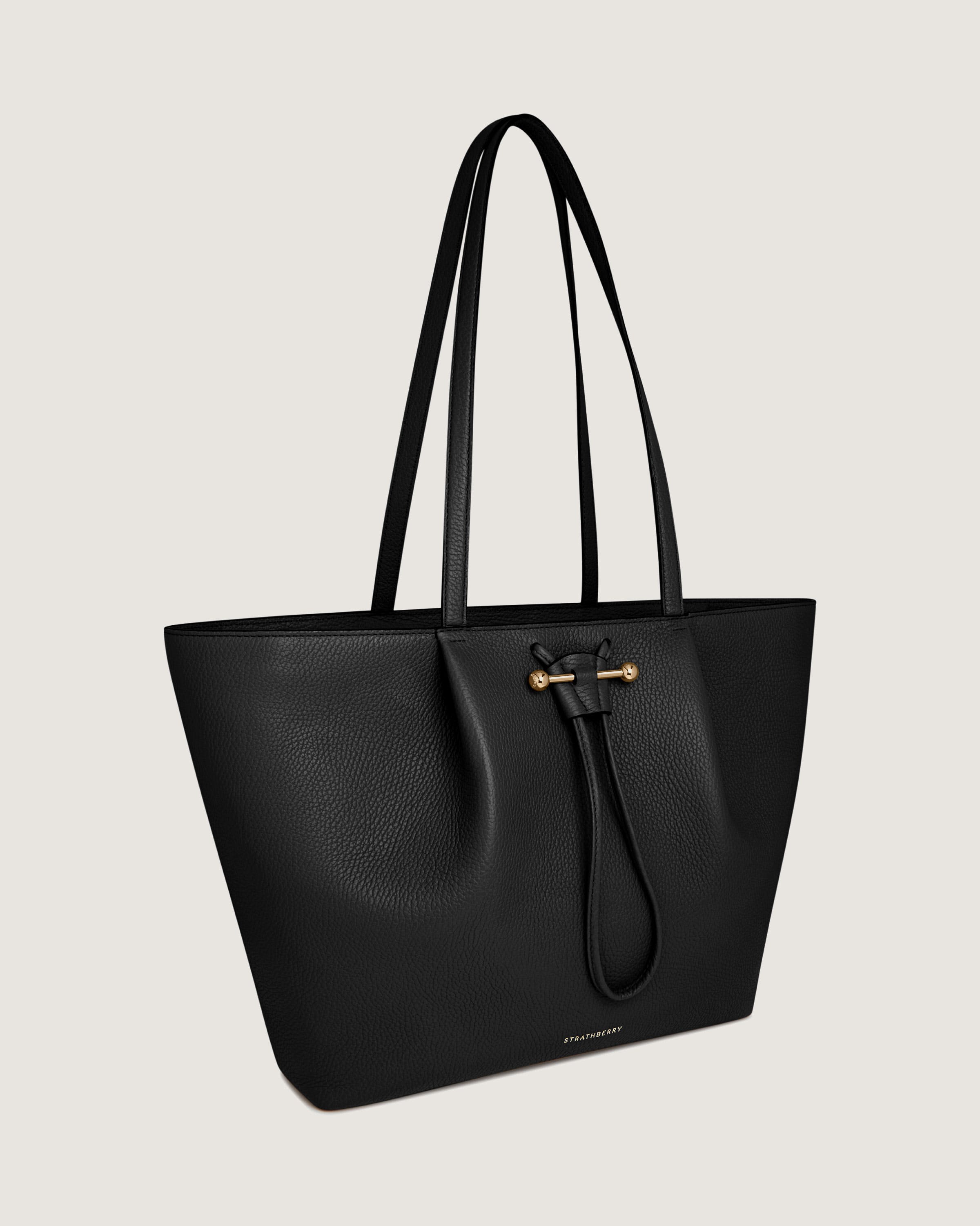 A black leather tote bag on a white background