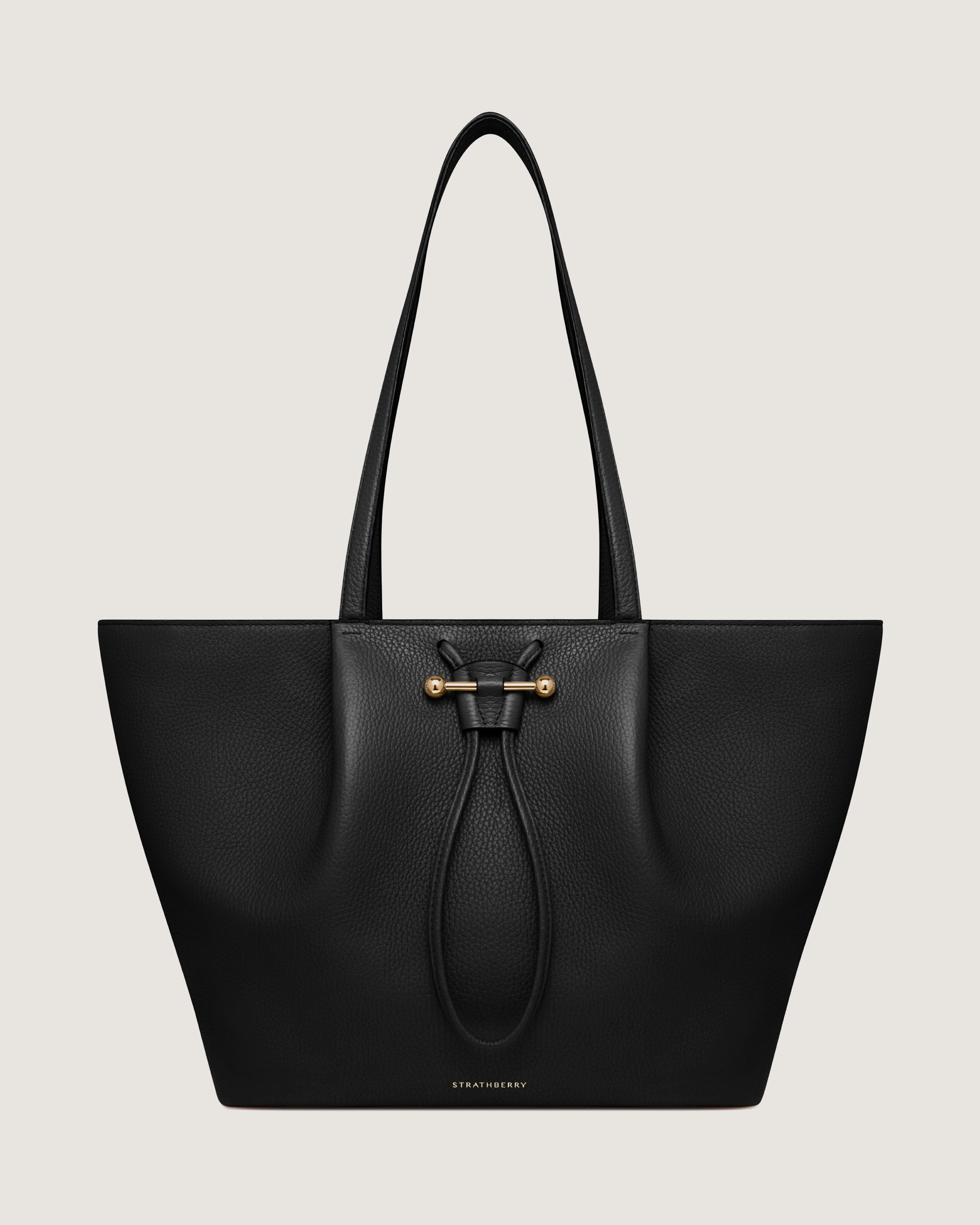 A black leather tote bag on a white background