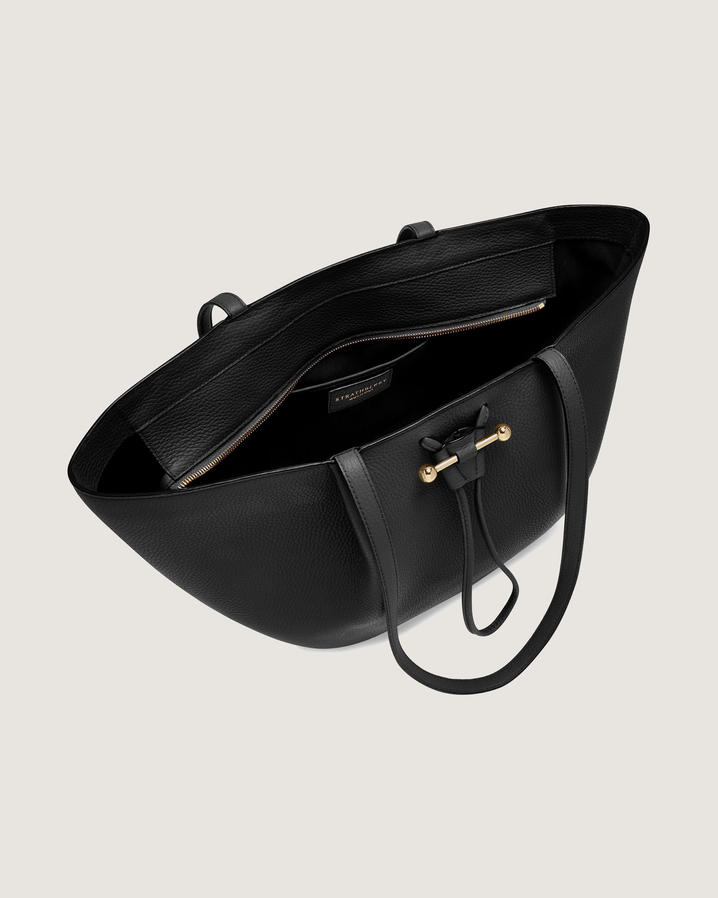 A black leather handbag with a long strap