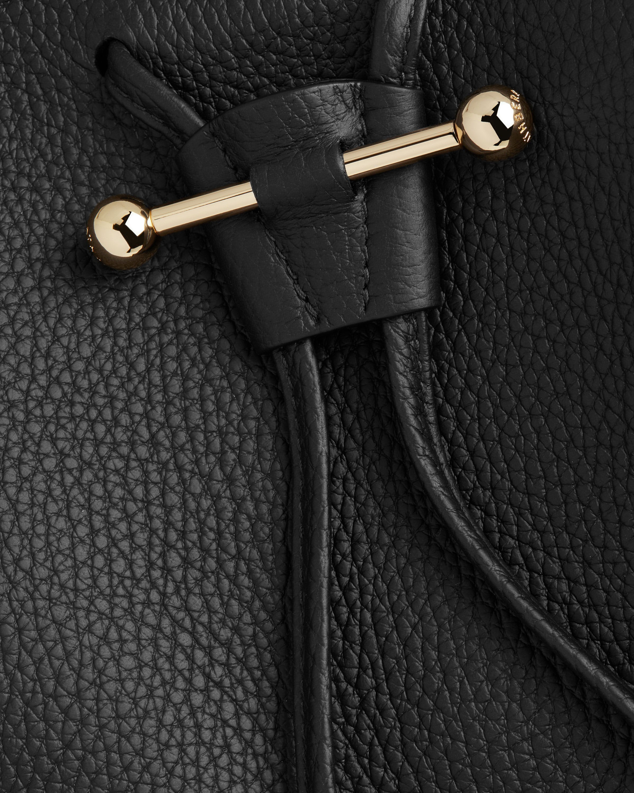 A close up of a black purse with a gold handle