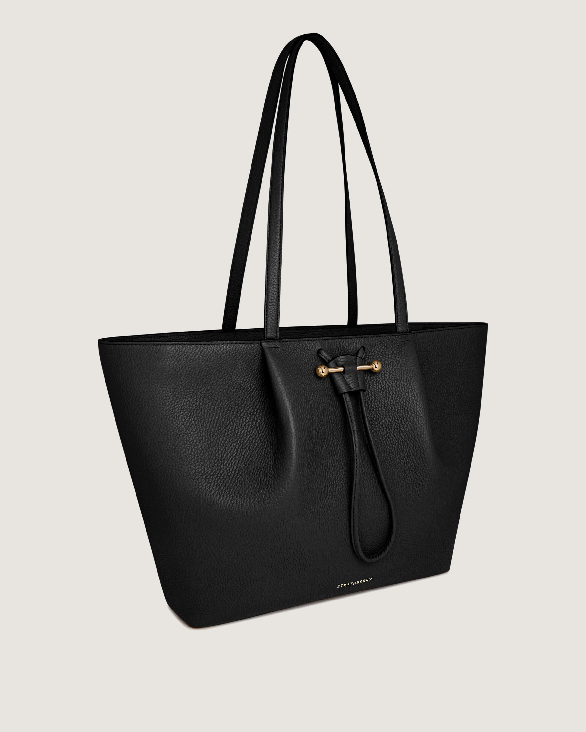 A black leather tote bag on a white background