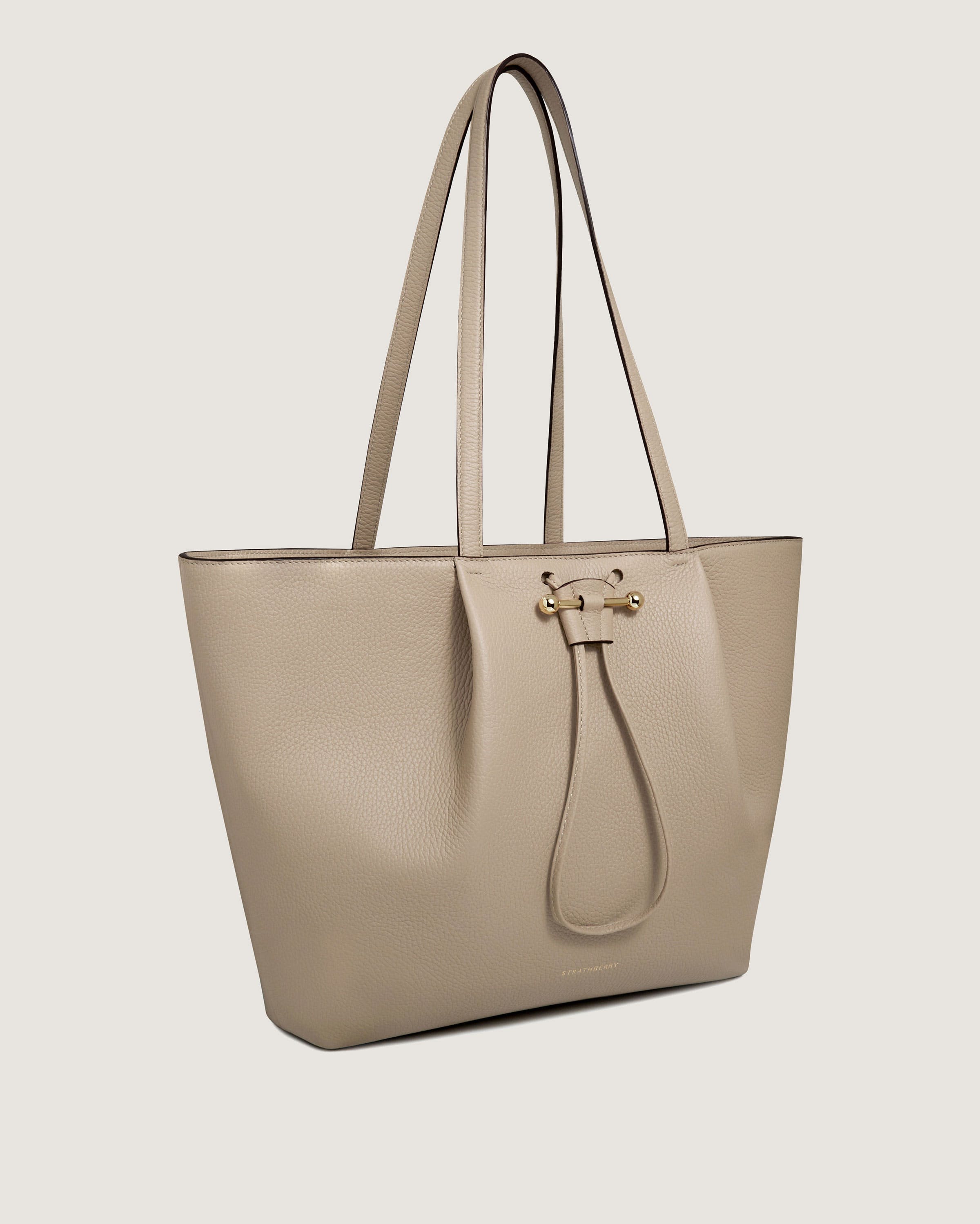 A beige leather tote bag on a white background