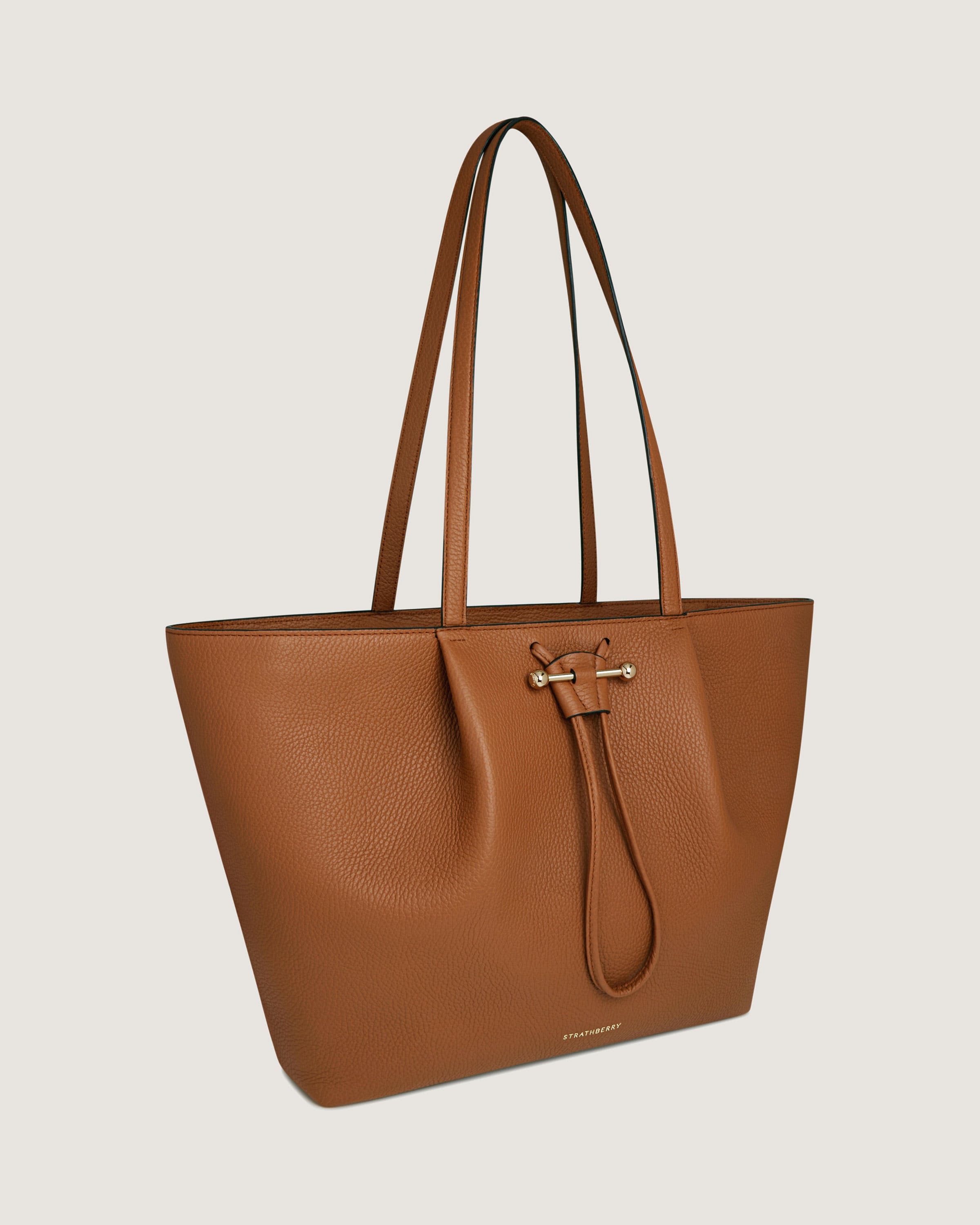 A brown leather tote bag on a white background