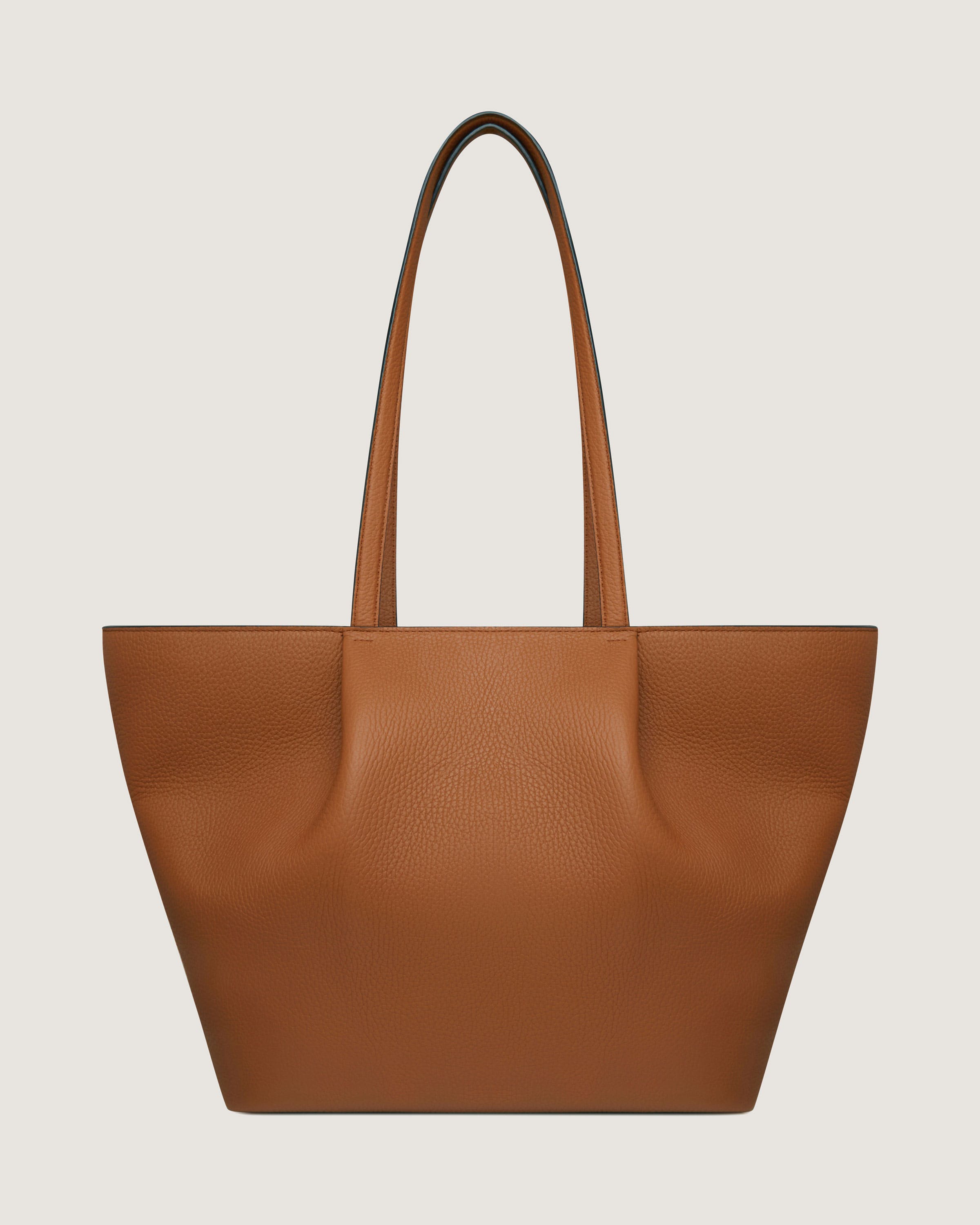 A brown leather tote bag on a white background