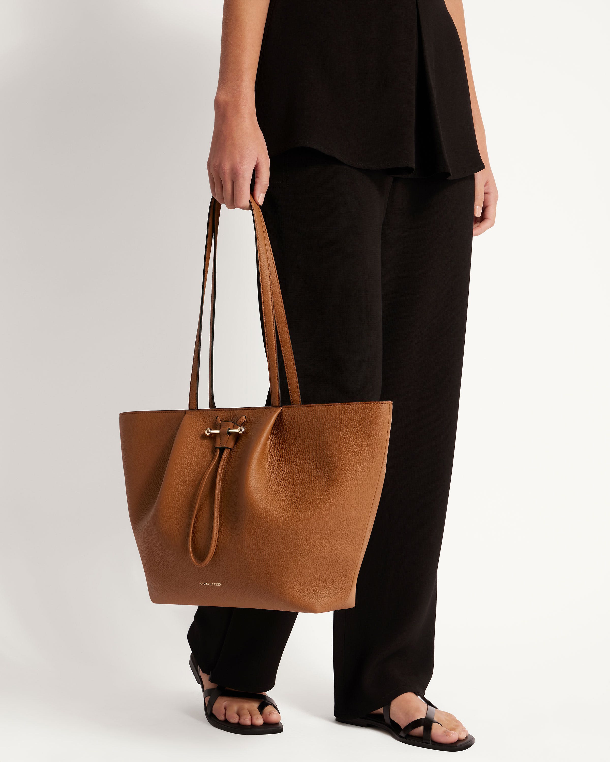 A woman is holding a brown bag in her hand