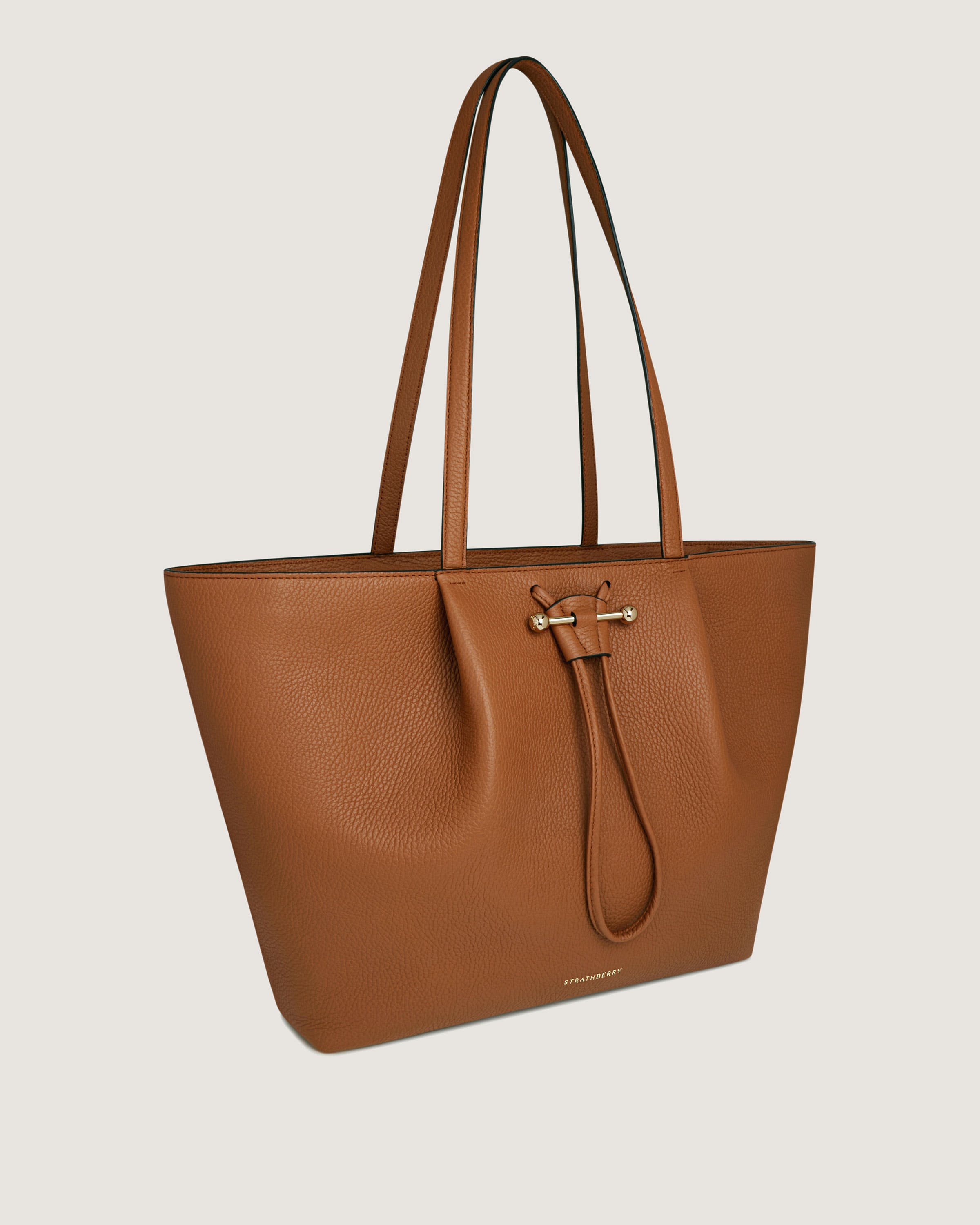 A brown leather tote bag with a zipper