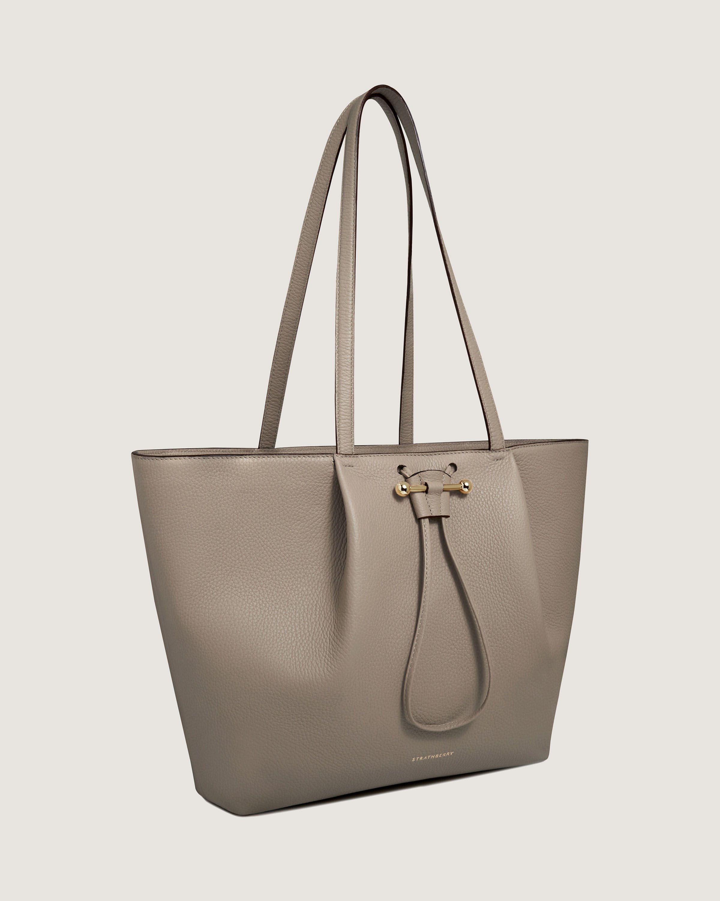 A grey leather tote bag on a white background