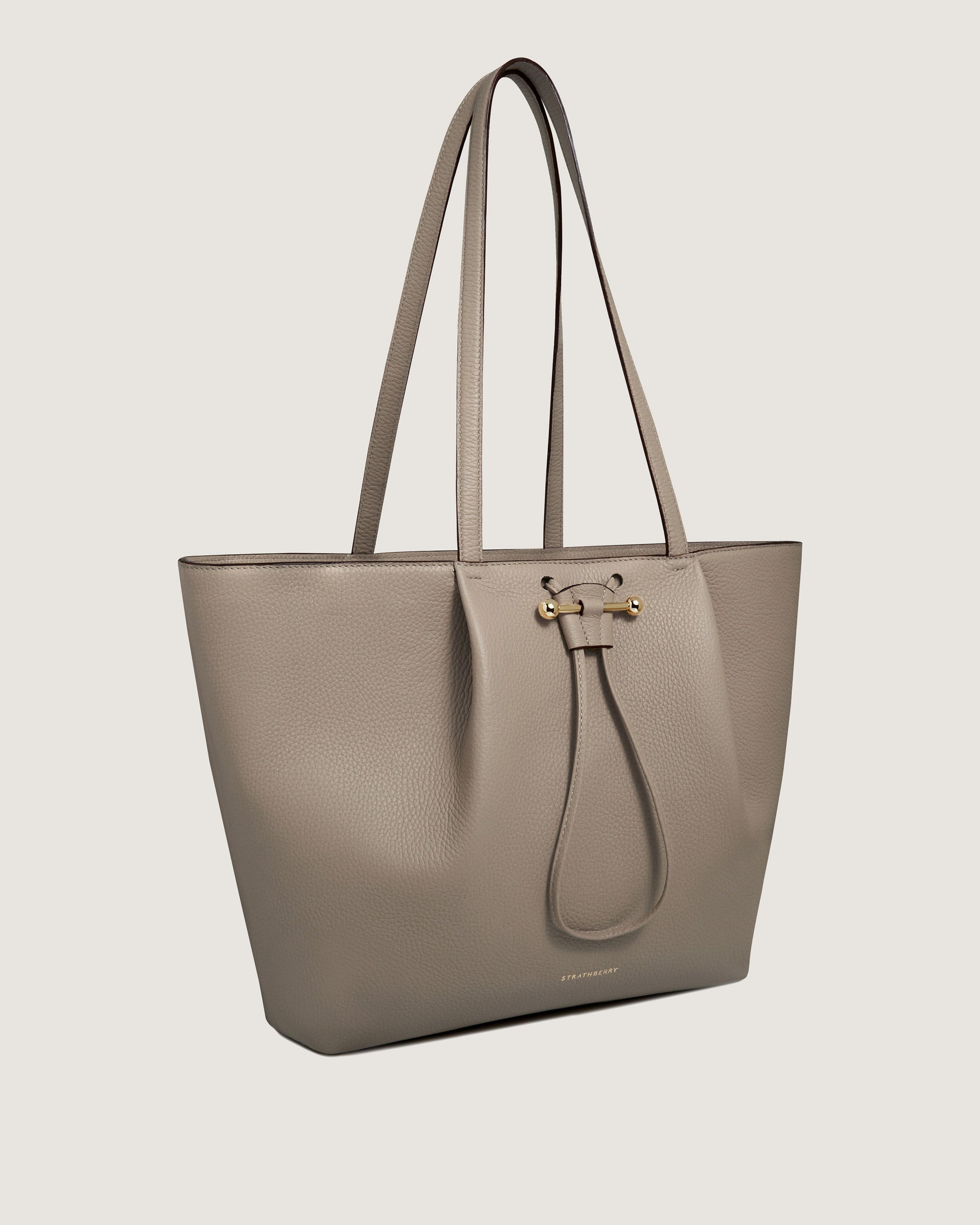 A beige leather tote bag on a white background