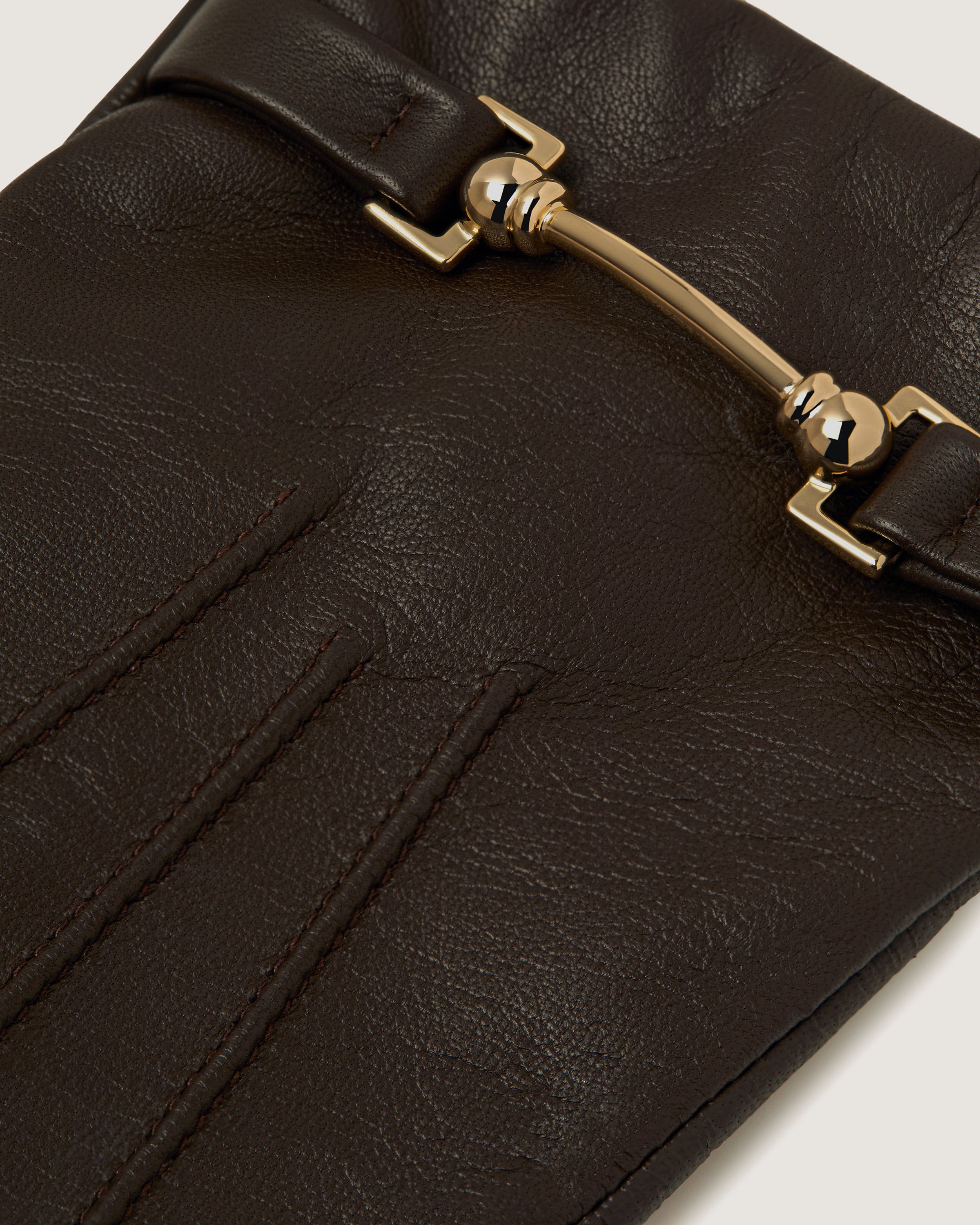 A close up of a black purse with a gold buckle