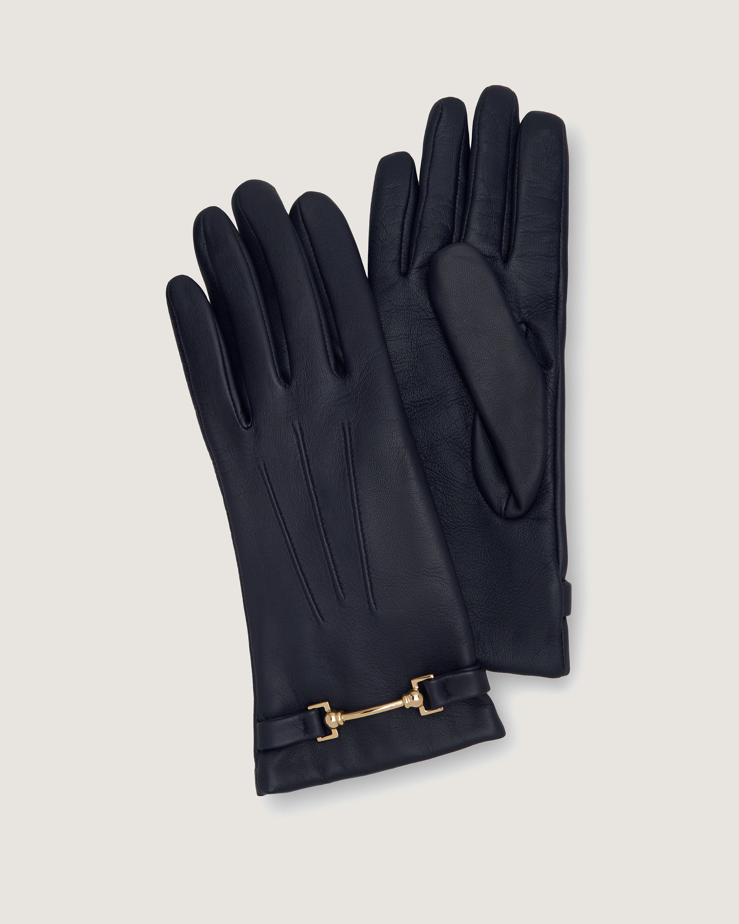 A pair of black leather gloves with a gold chain