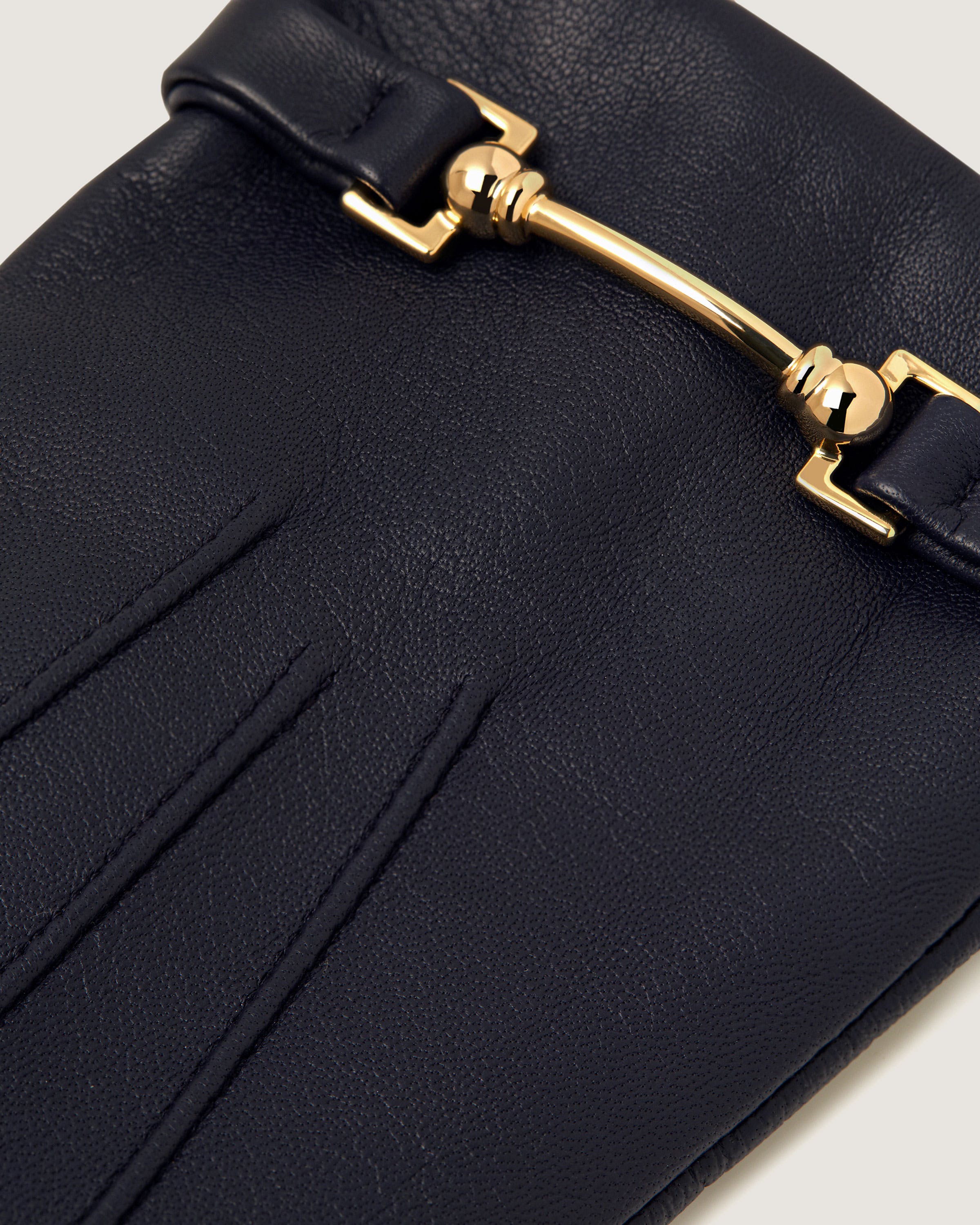 A close up of a black purse with a gold handle