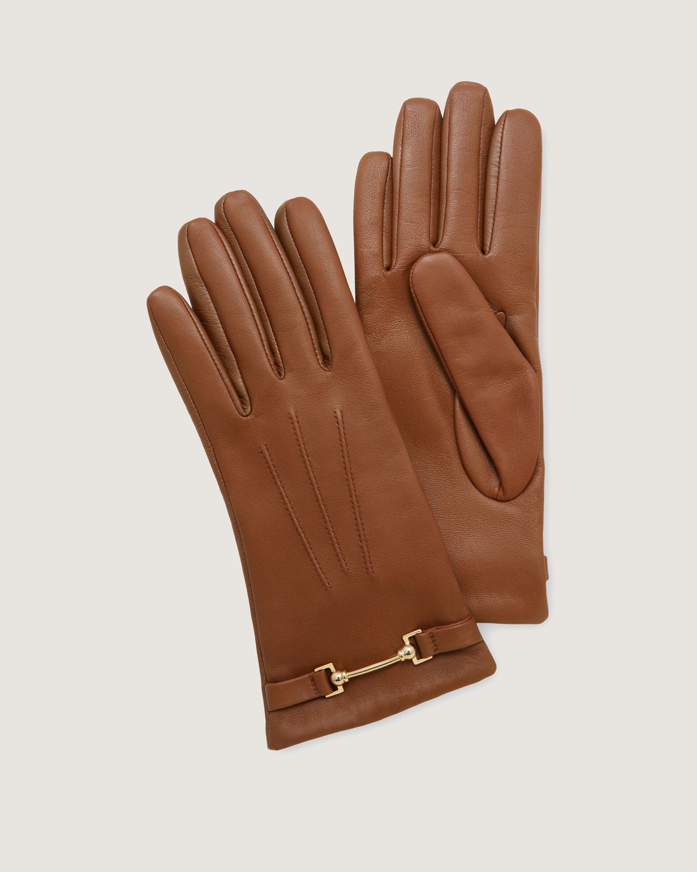 A pair of brown leather gloves with a gold buckle