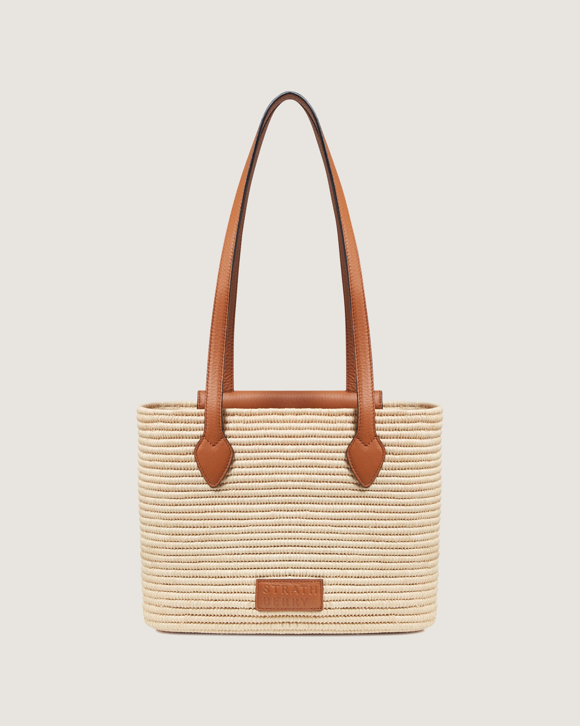 A straw bag with a brown leather handle