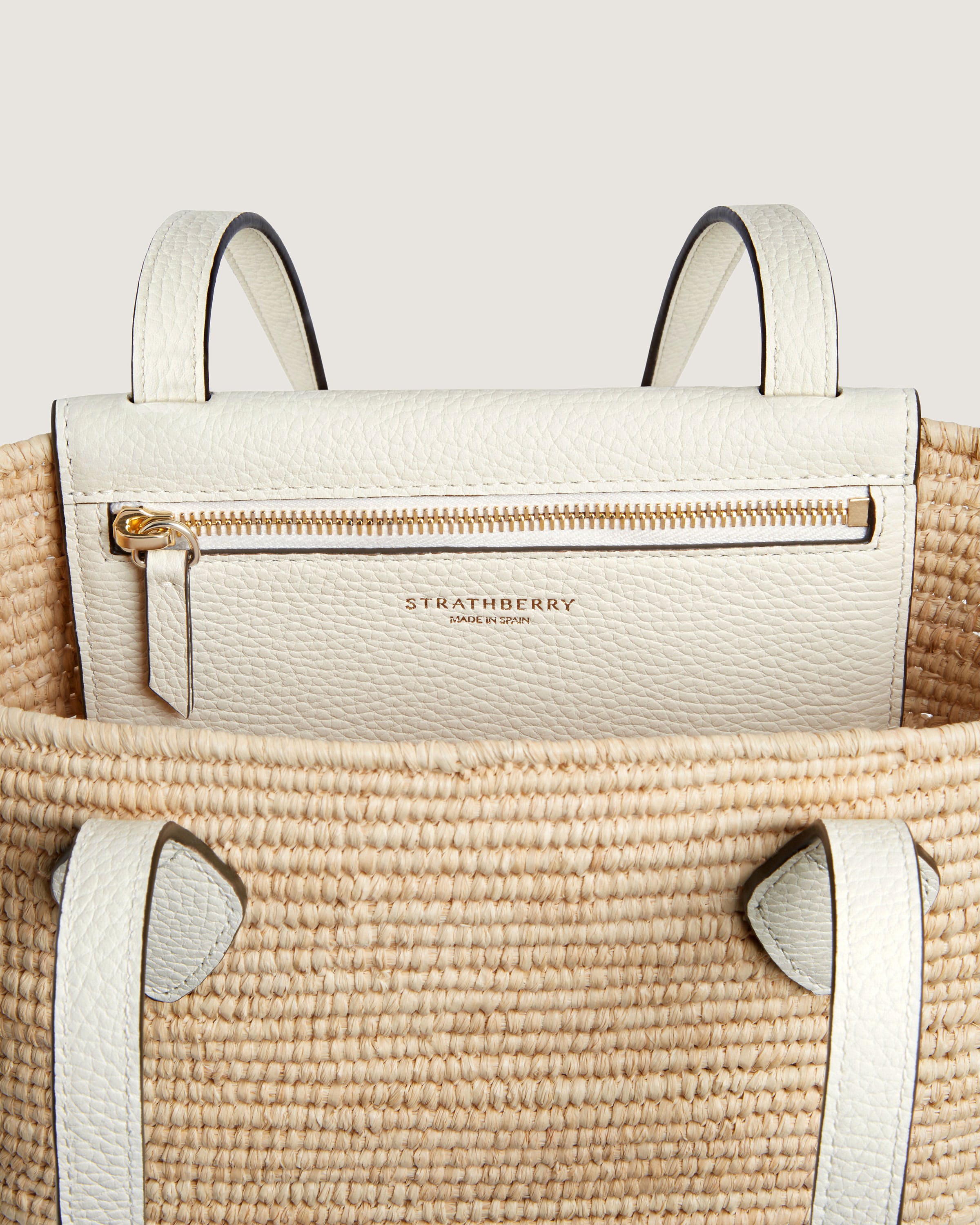 A white handbag with two handles and a handle