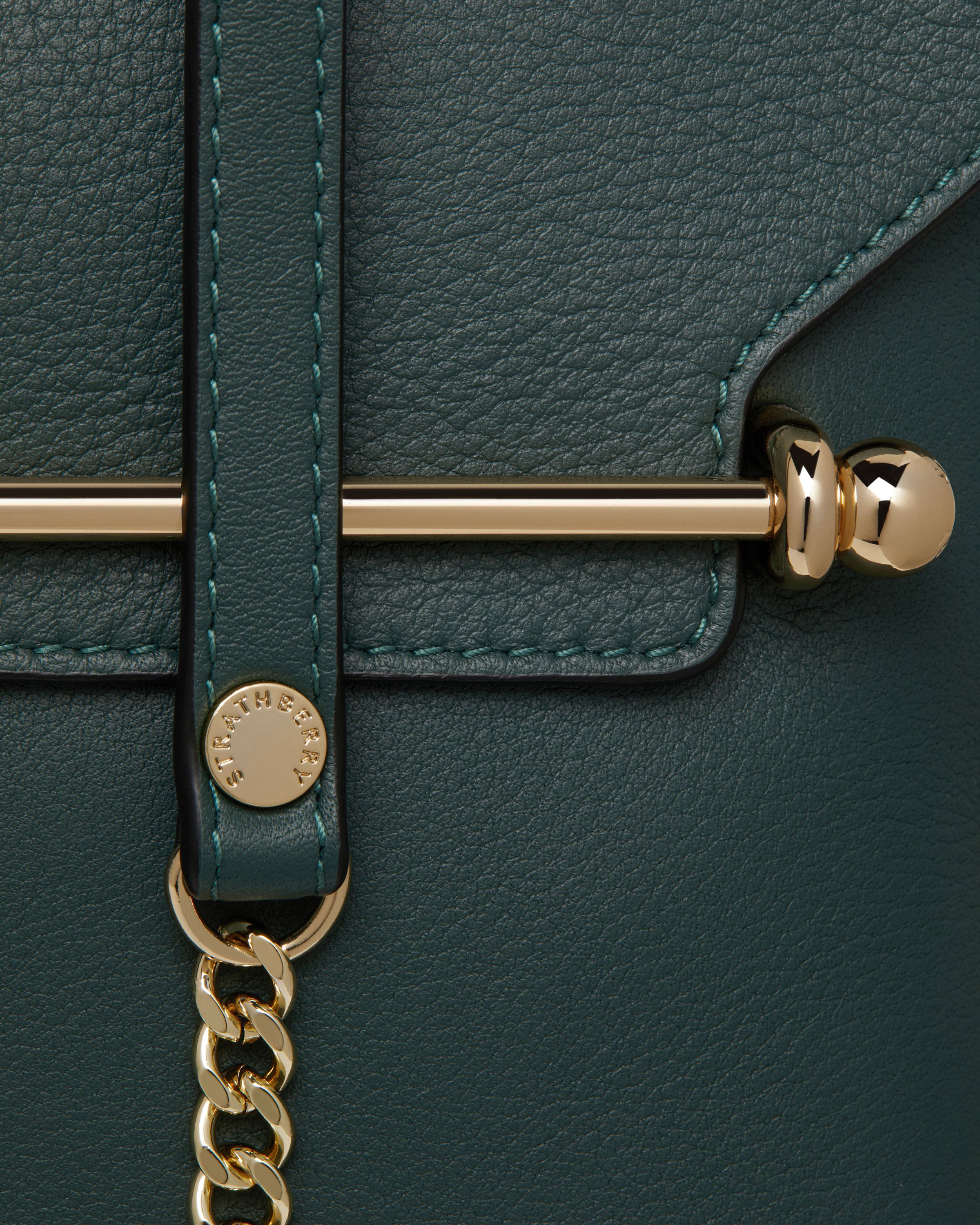 A close up of a green and gold purse