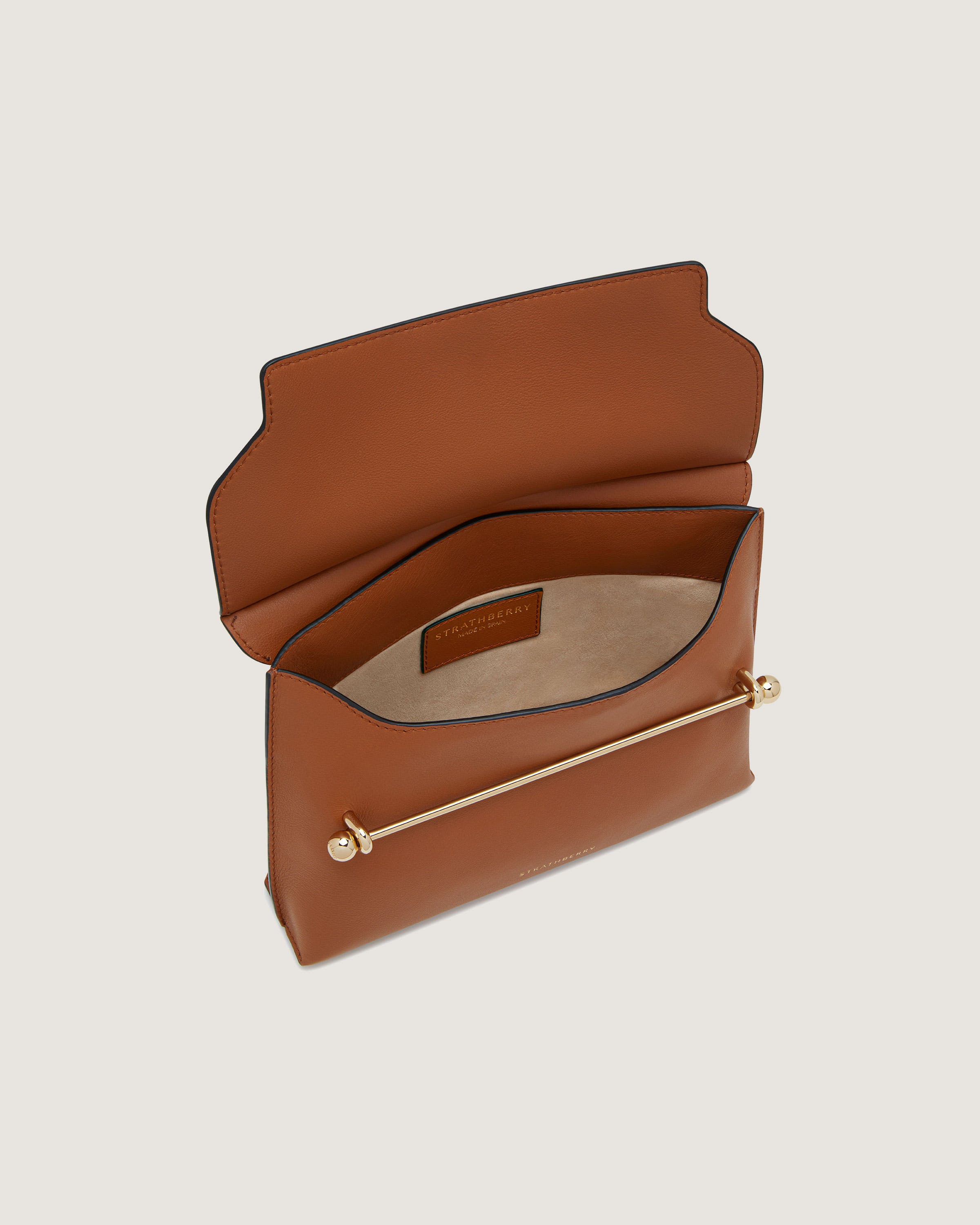 A brown leather purse with a gold handle