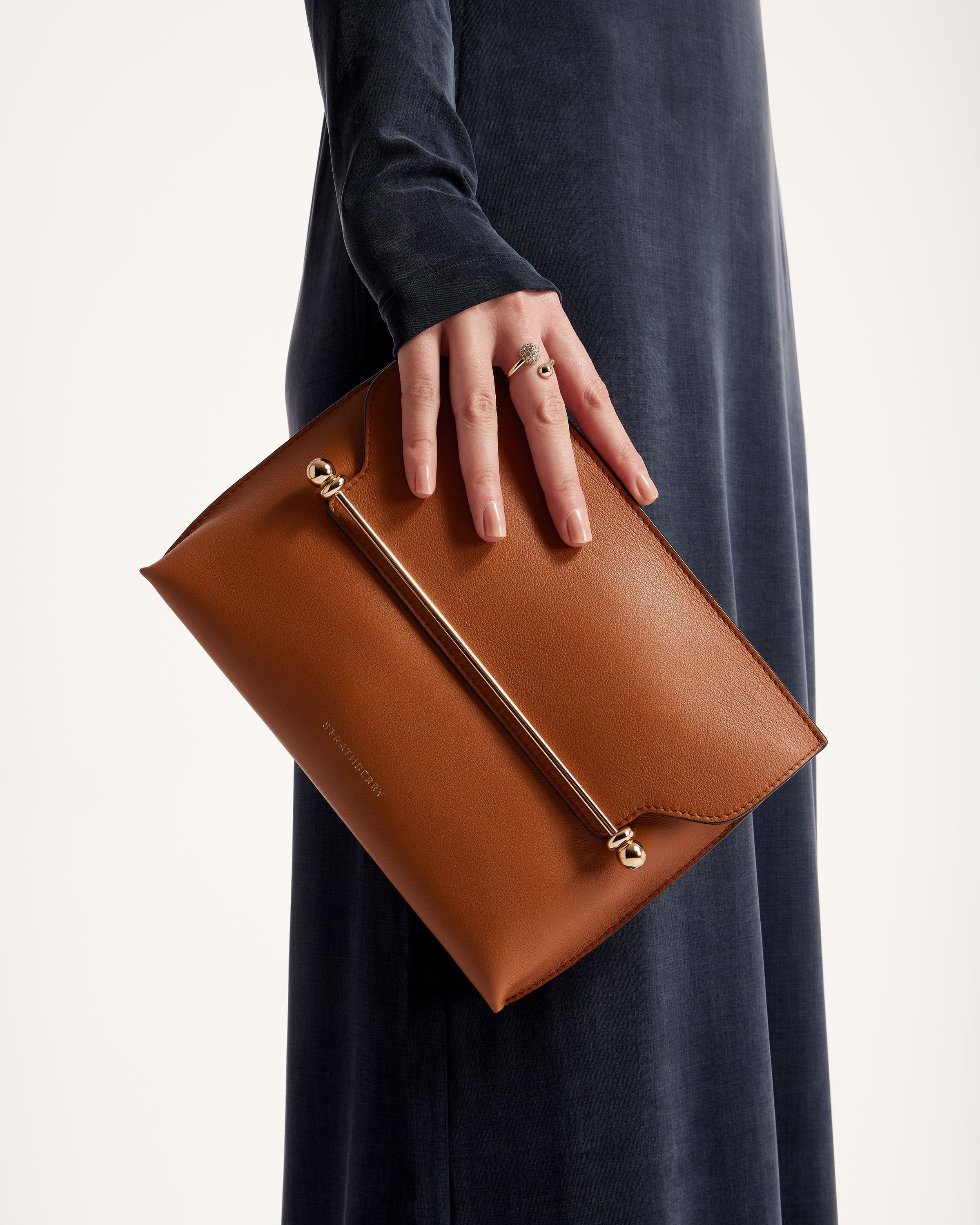 A woman is holding a brown leather purse