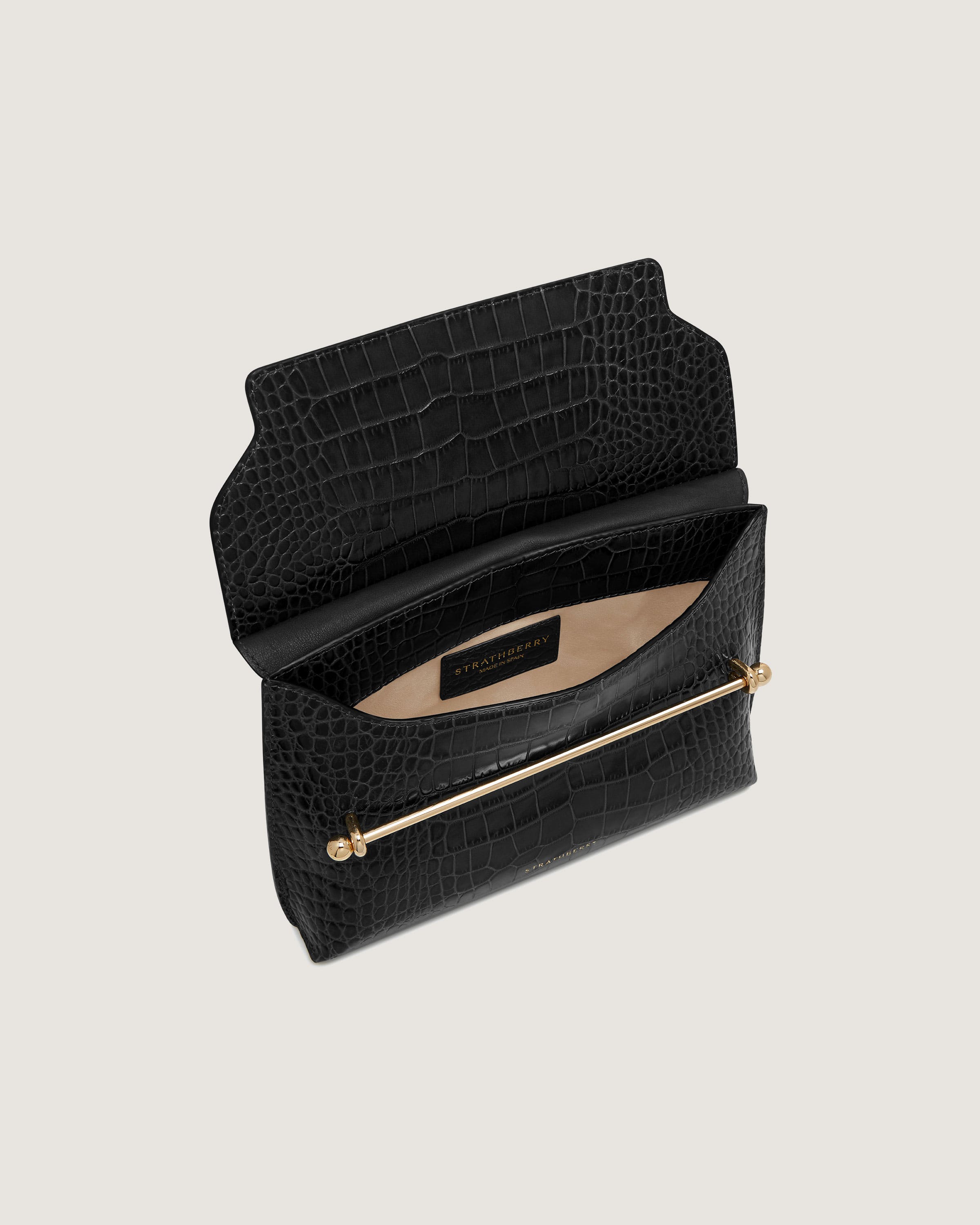 A black purse with a gold handle