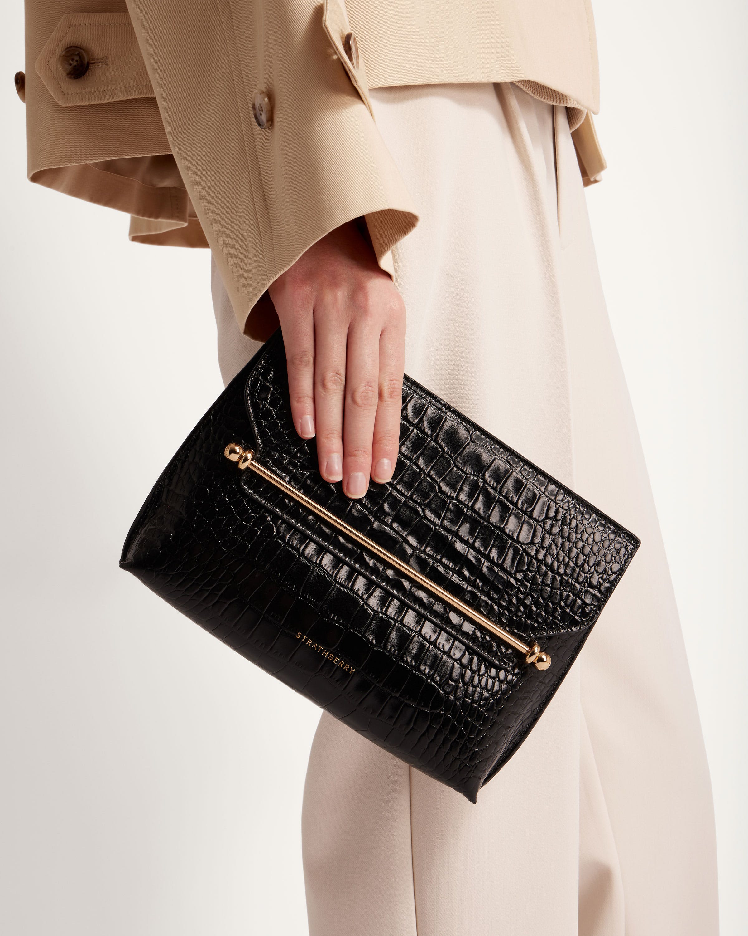 A woman's hand holding a black purse