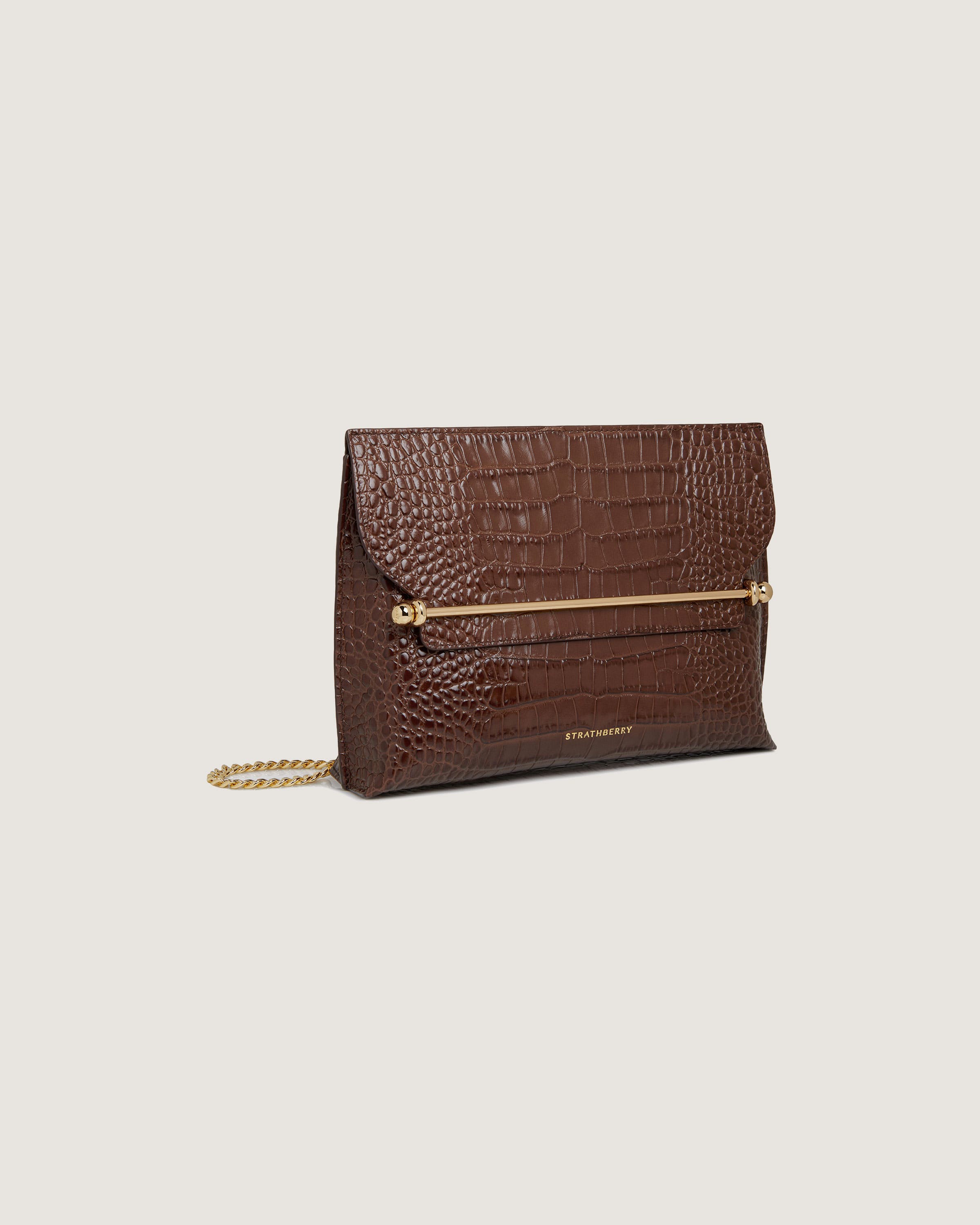 A brown clutch bag with a gold chain