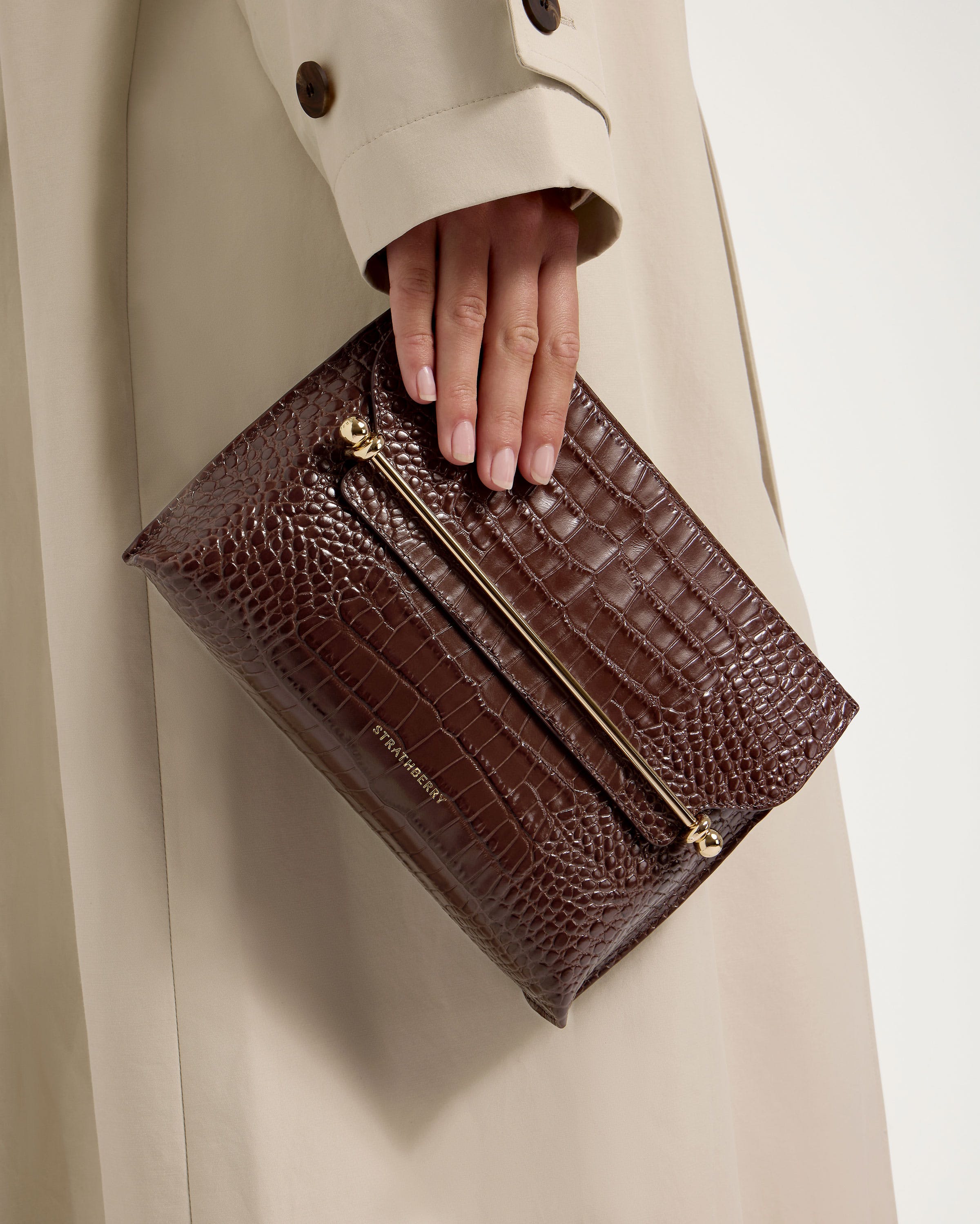 A woman's hand holding a brown purse