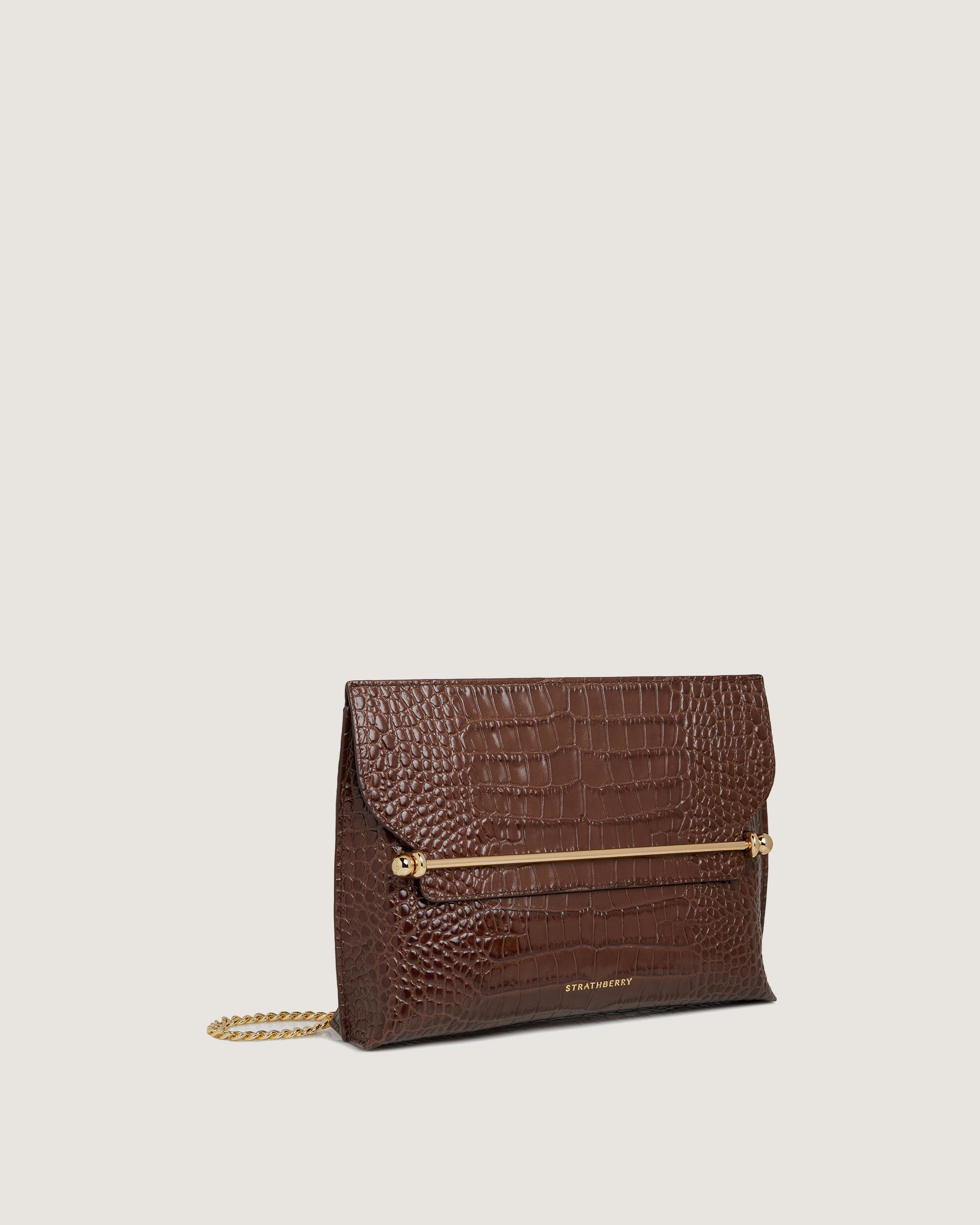 A brown clutch bag with a gold chain