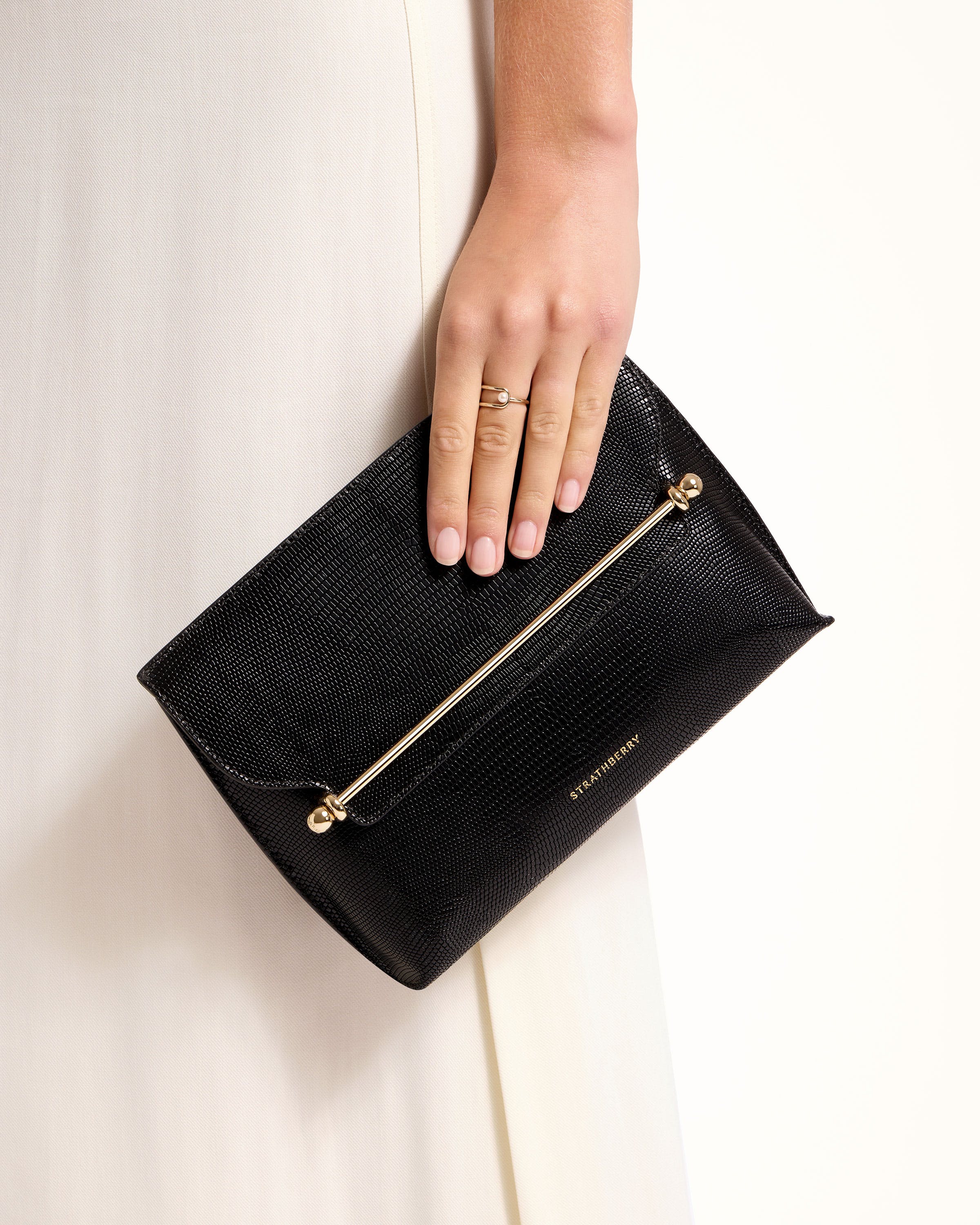 A woman's hand holding a black purse