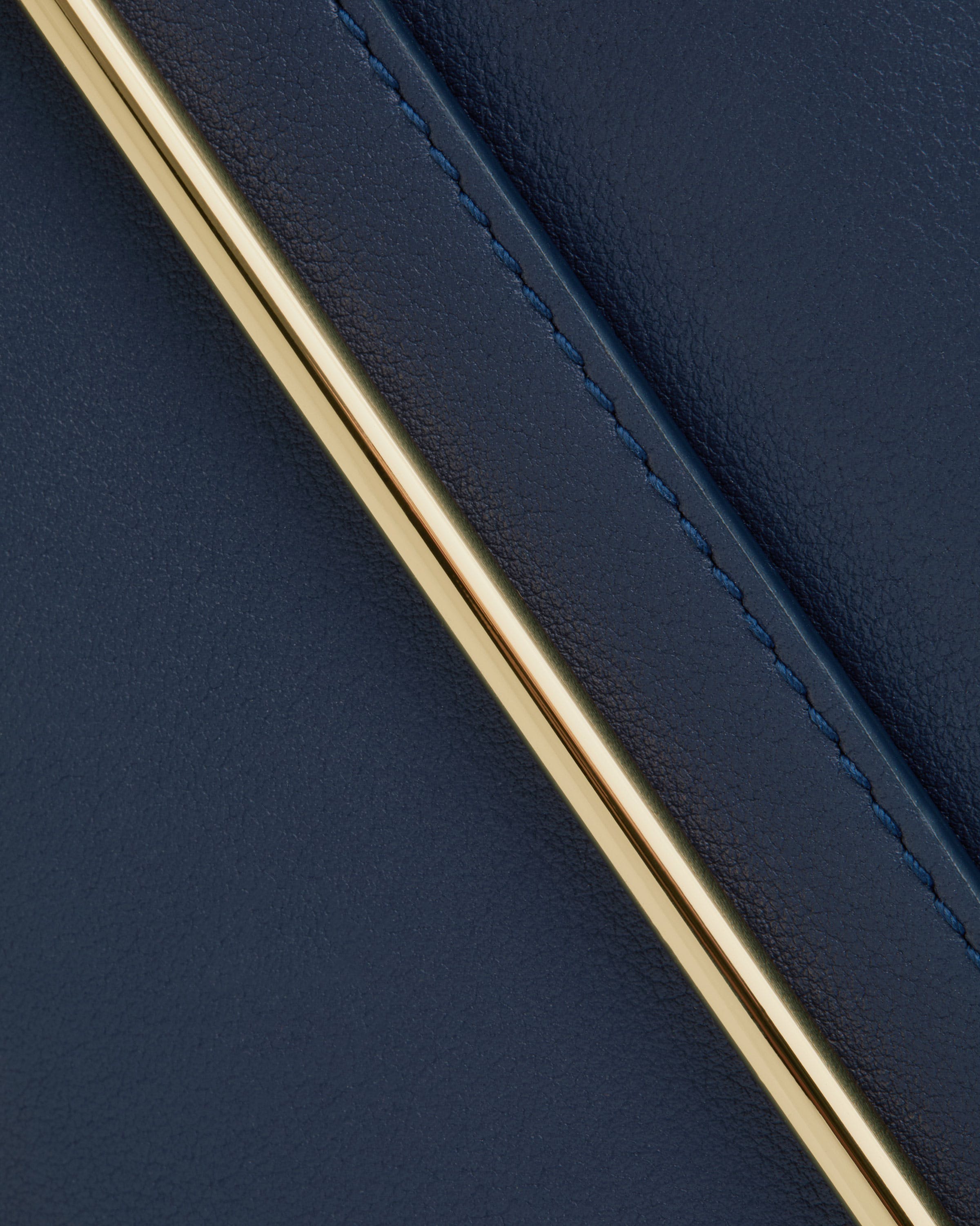 A close up of a gold metal object on a blue surface