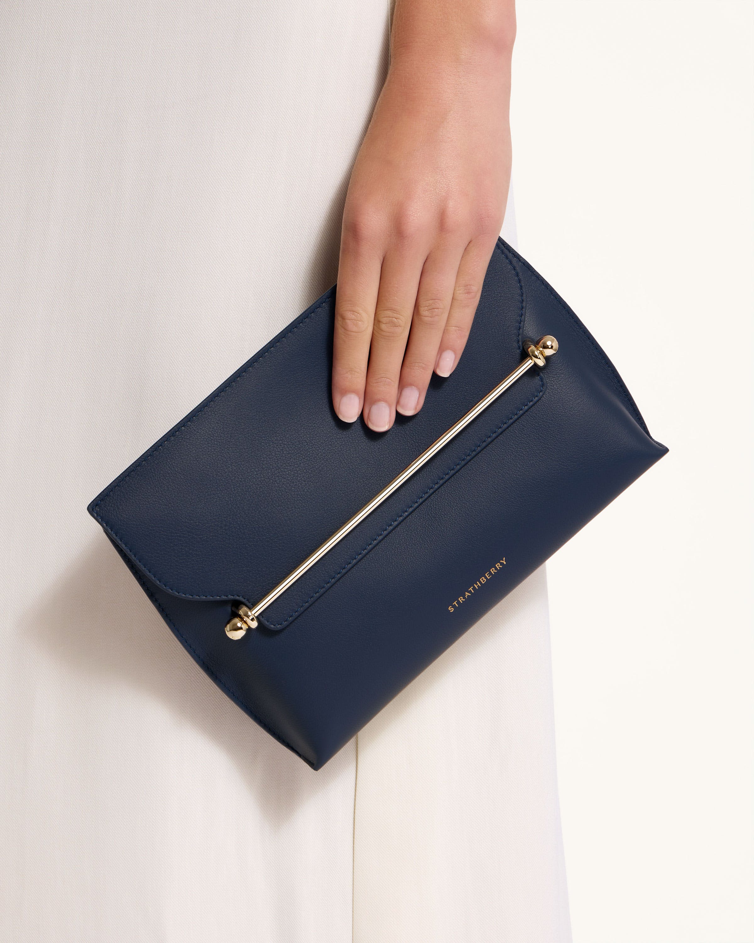 A woman's hand holding a blue purse