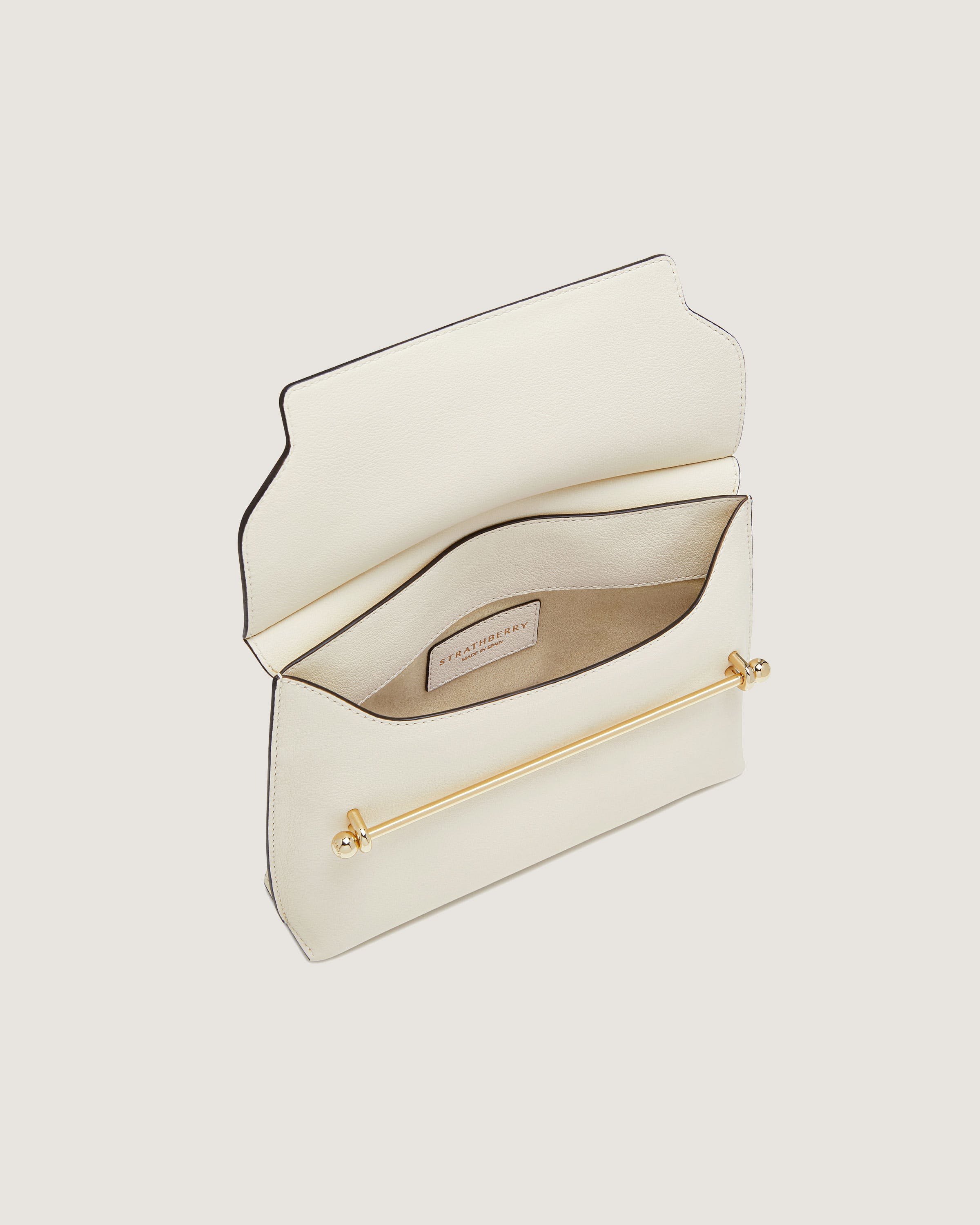 A white clutch bag with a gold handle