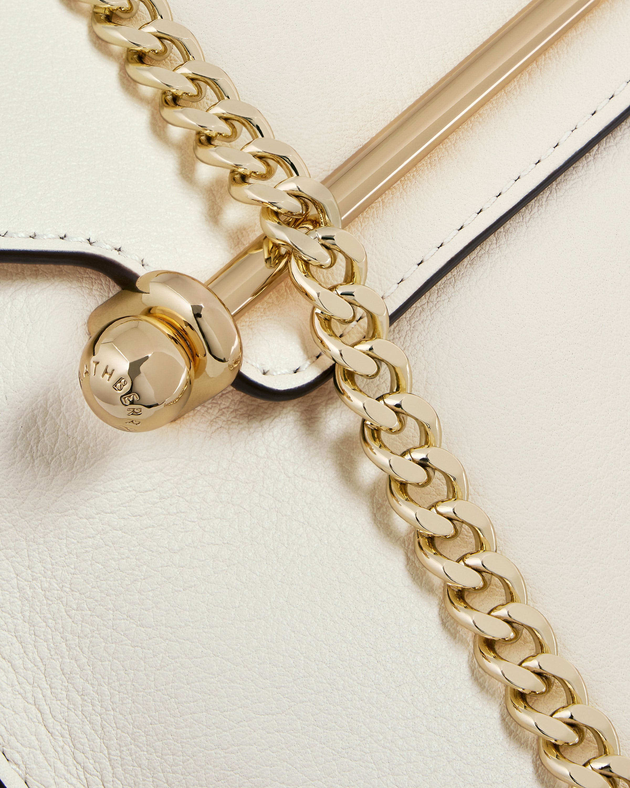 A close up of a white and gold purse