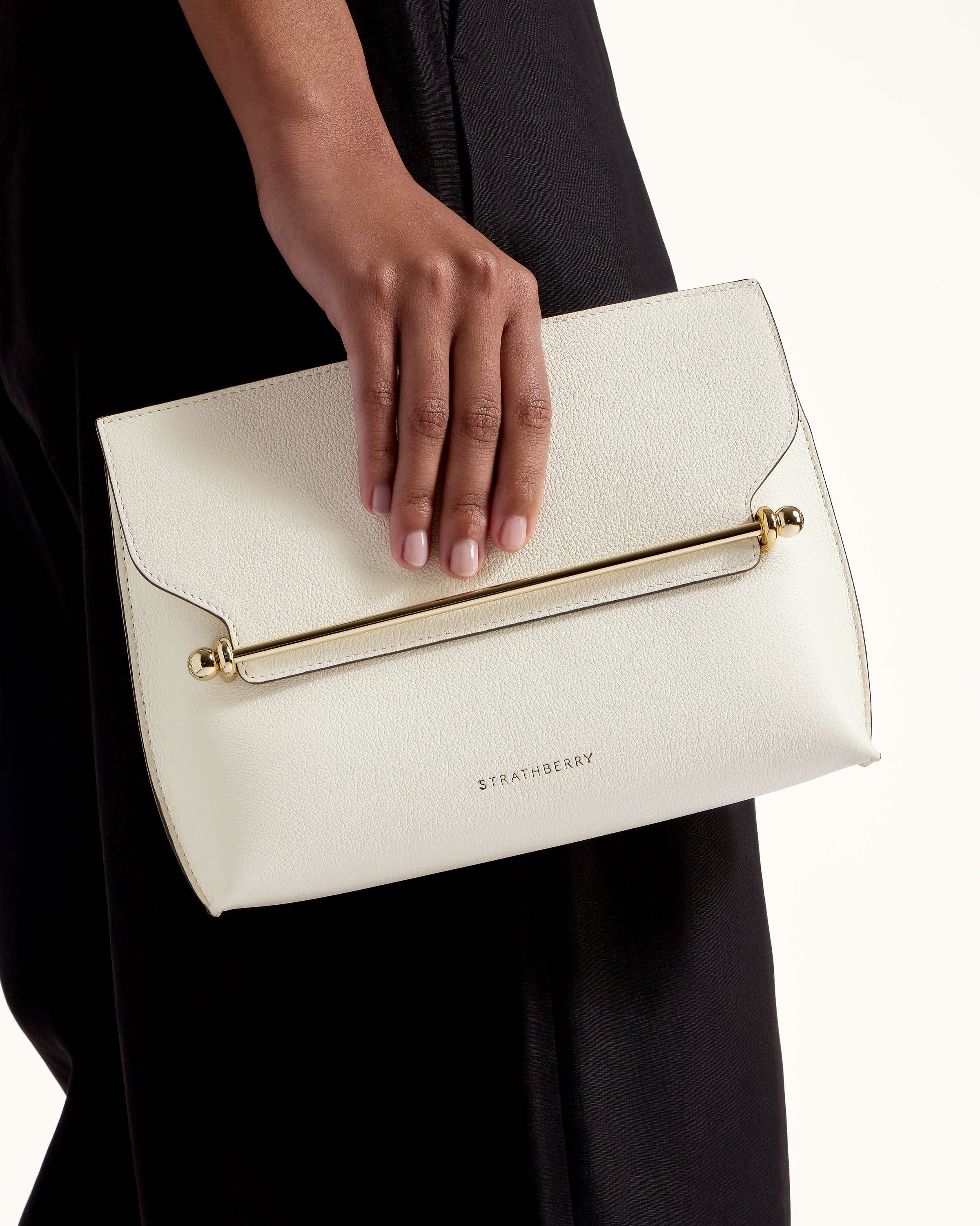 A woman's hand holding a white purse