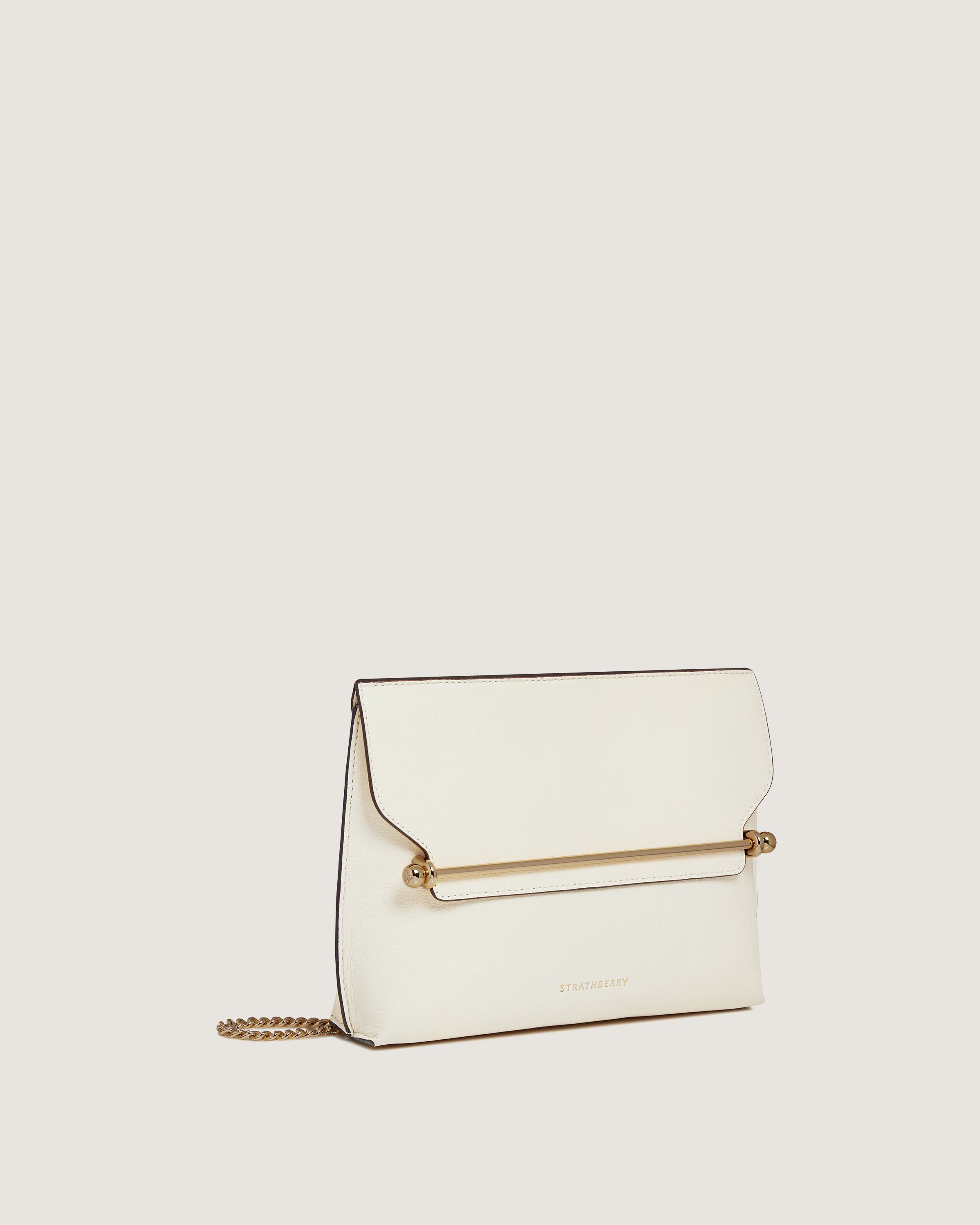 A white purse with a gold chain hanging from it