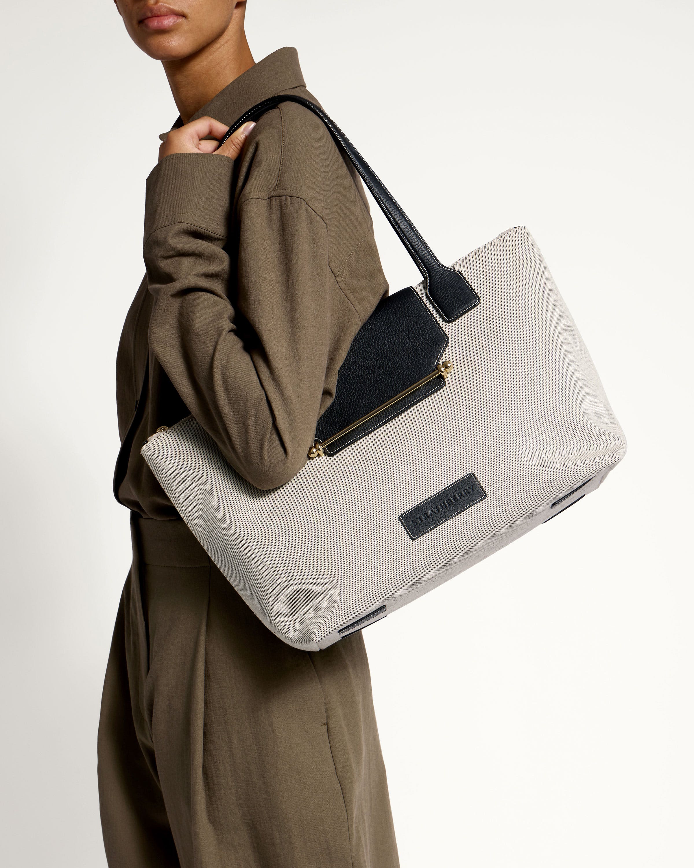 A woman holding a large white and black bag