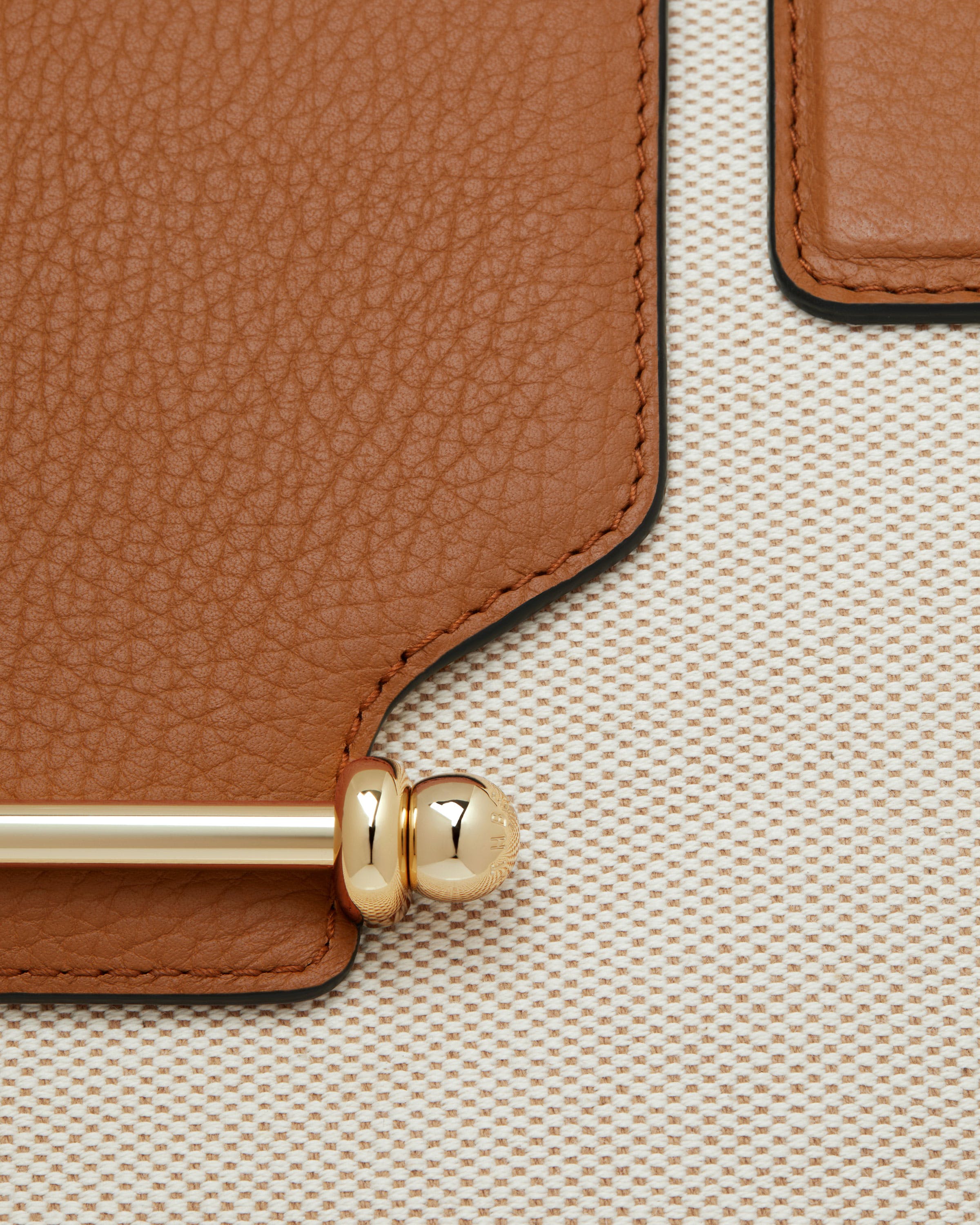 A close up of a brown and beige purse