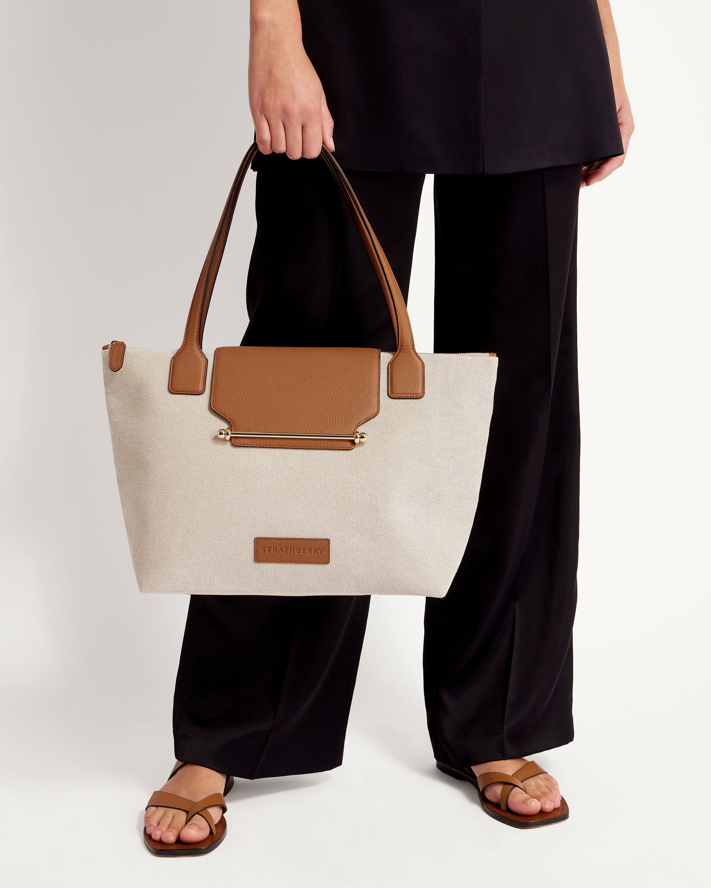 A woman holding a white and brown bag