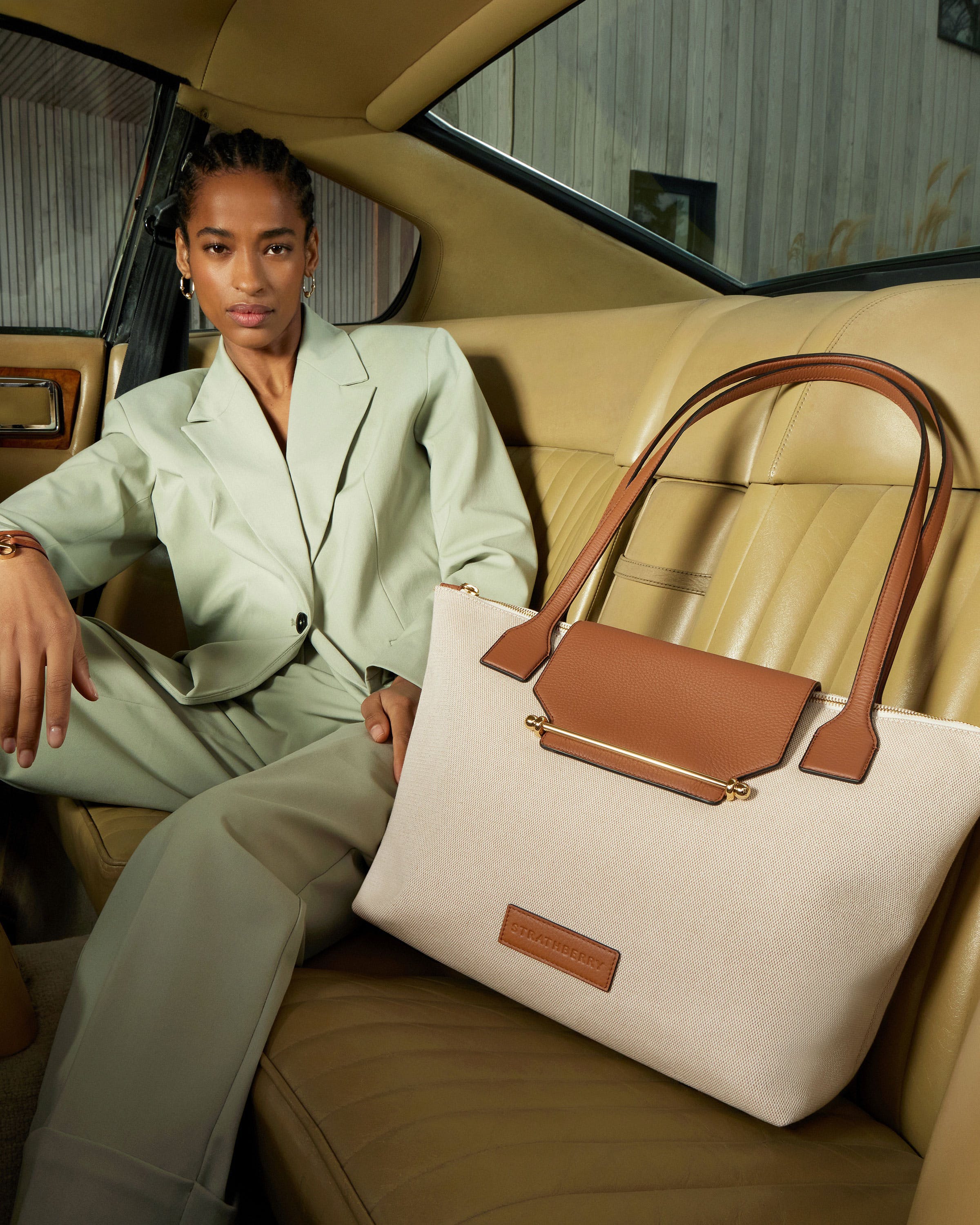 A woman sitting in a car holding a purse