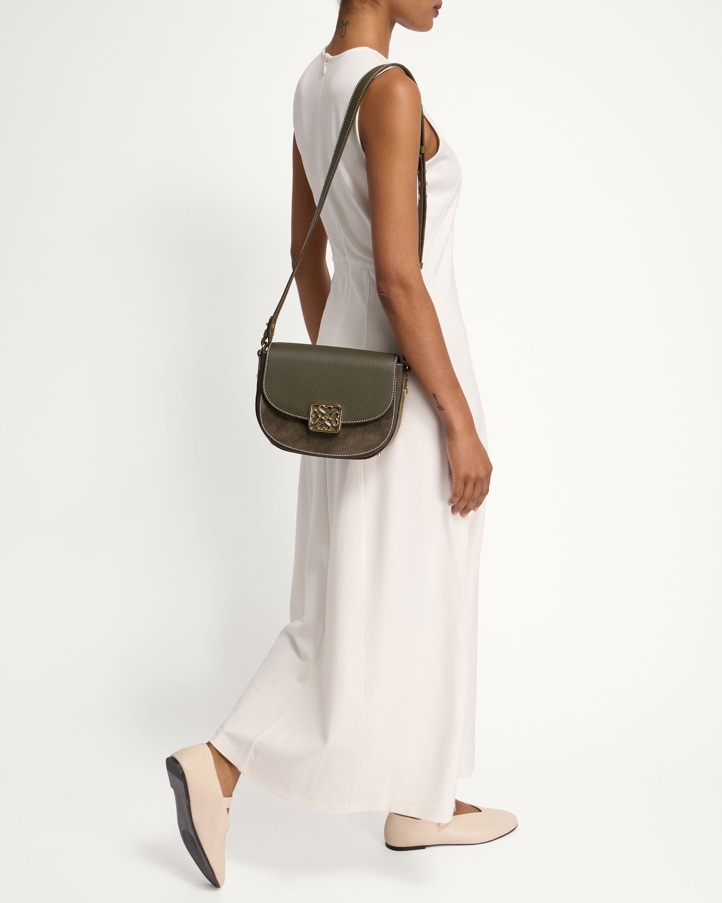 A woman in a white dress carrying a green handbag