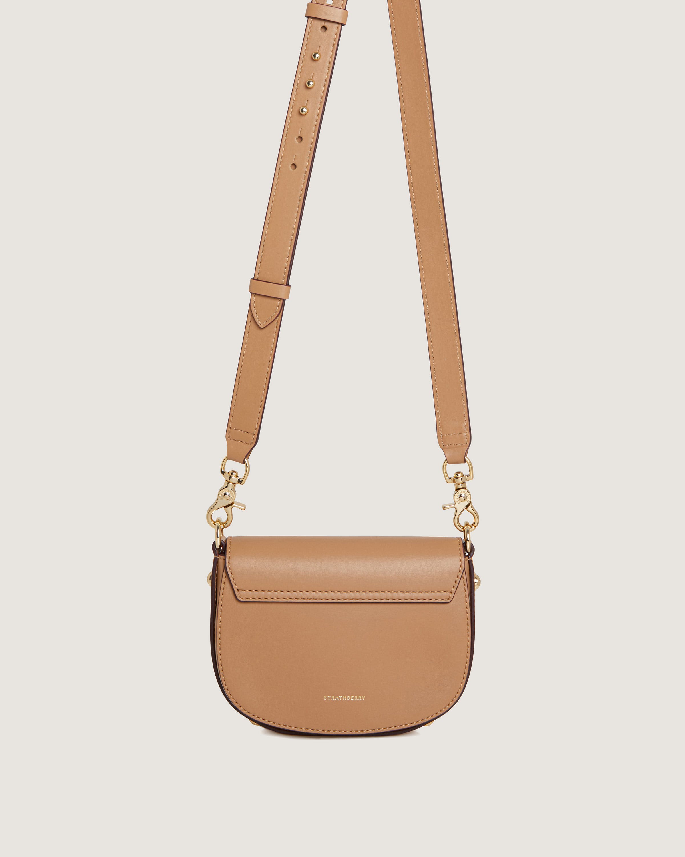 A tan cross body bag on a white background