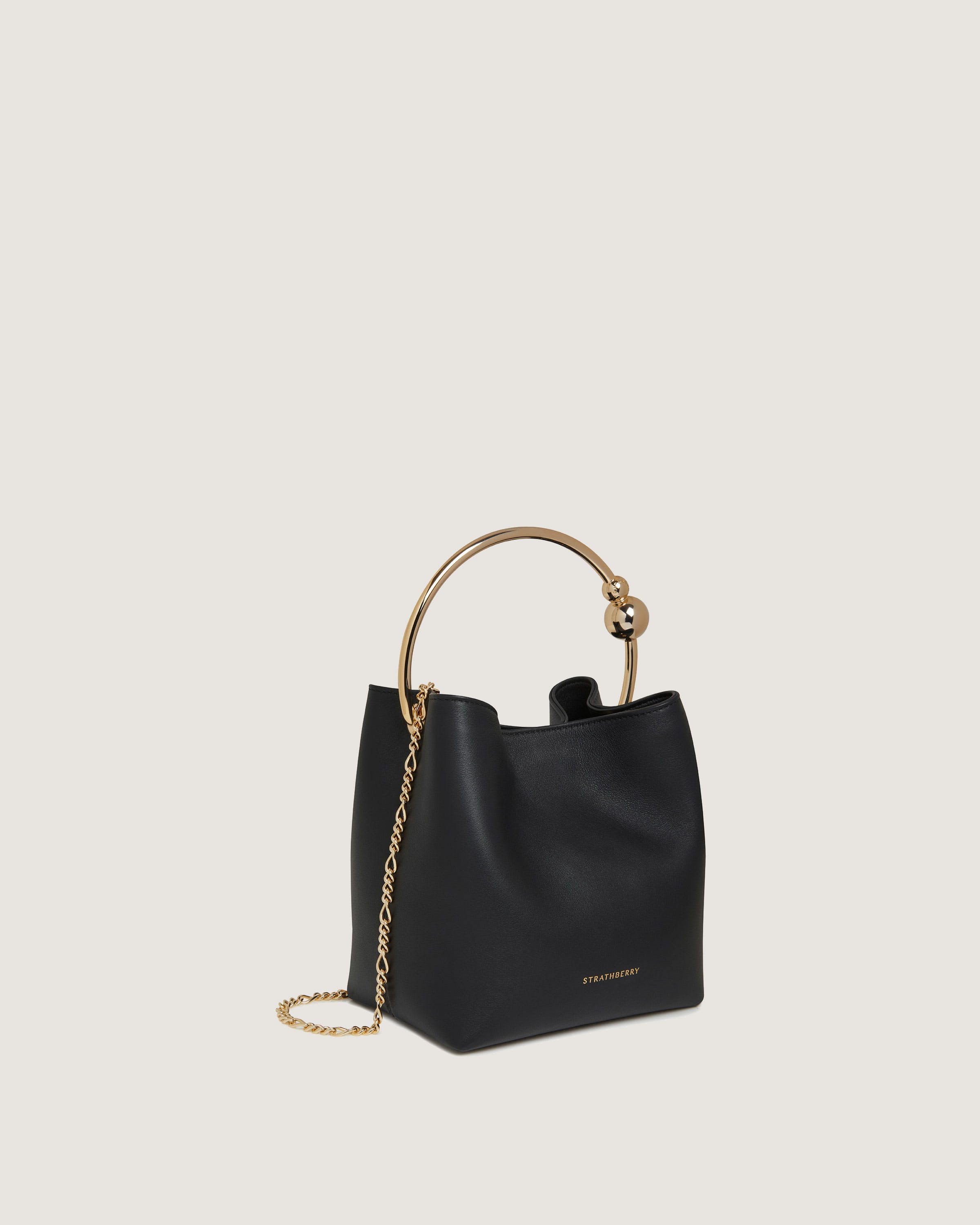 A black handbag with a gold handle