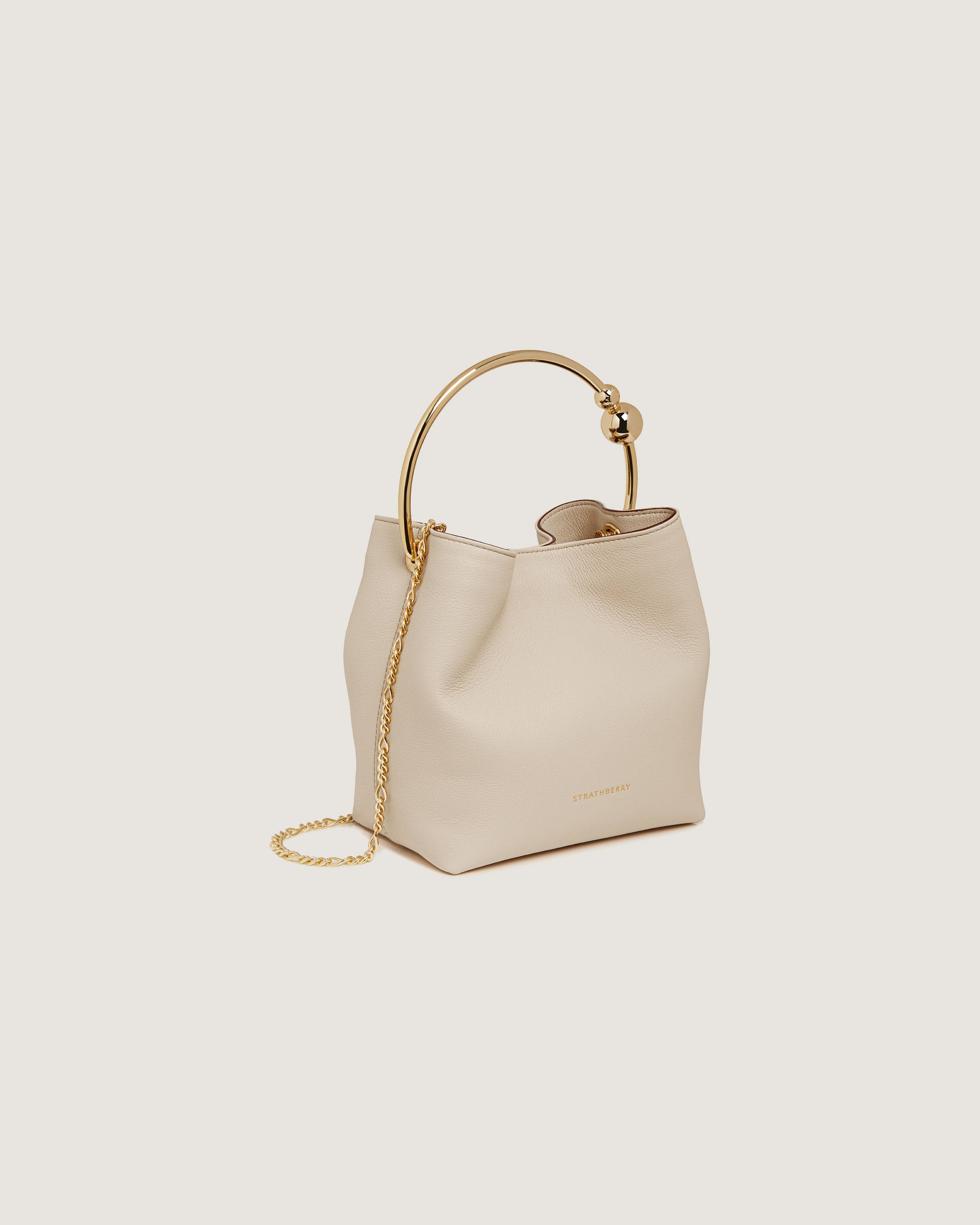 A white handbag with a gold handle