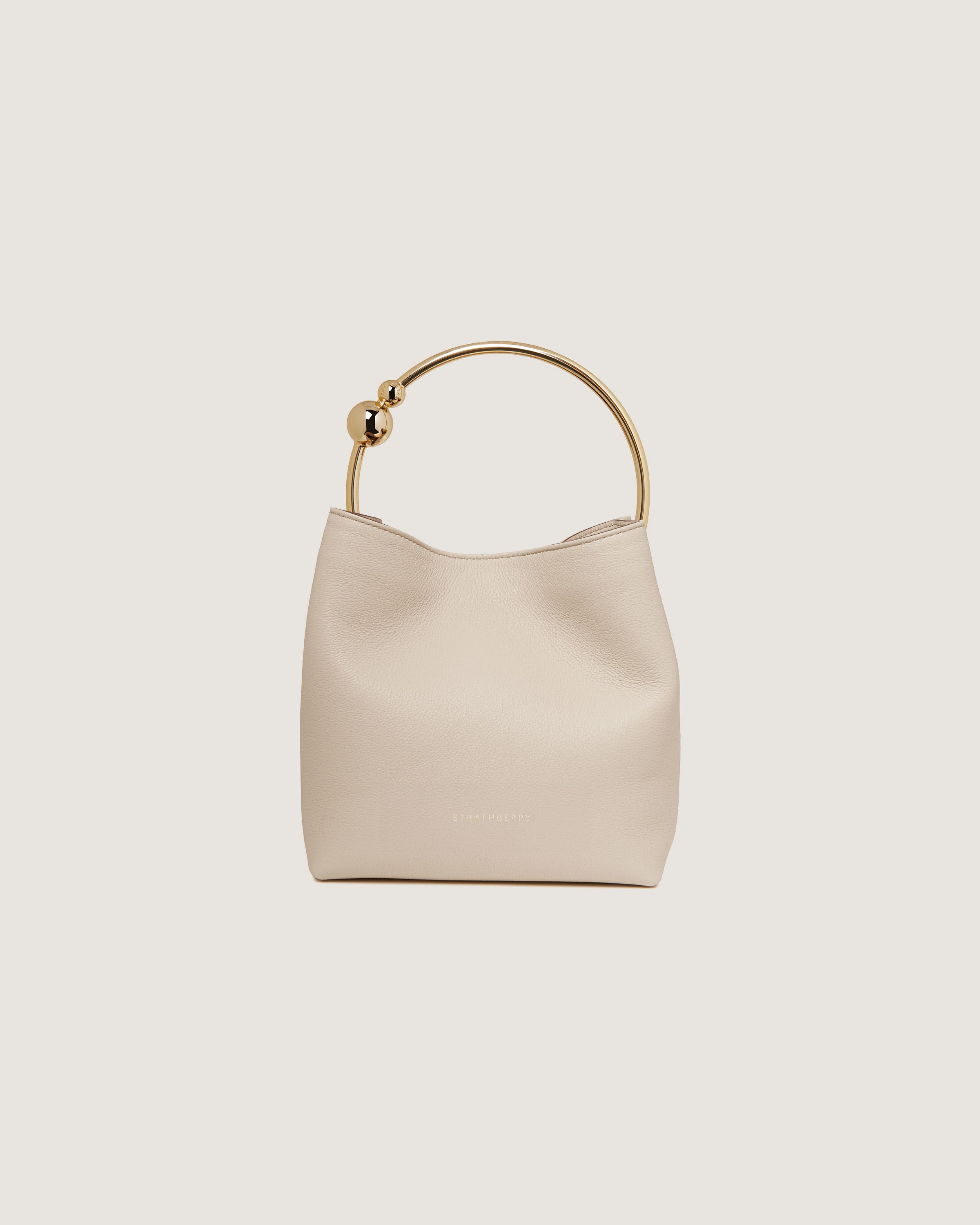 A white handbag with a gold handle