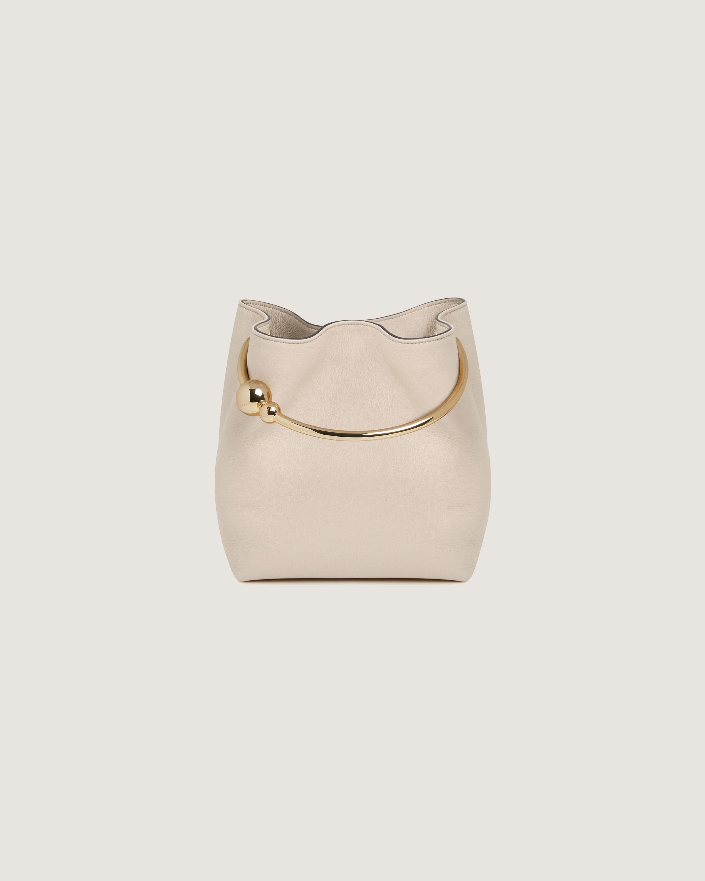 A white handbag with a gold handle